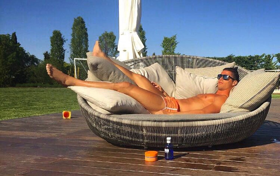 Cristiano Ronaldo relaxing outdoors barefoot in the sun, showing the visible tendons and foot structure associated with world-class footballers discussed in this article.