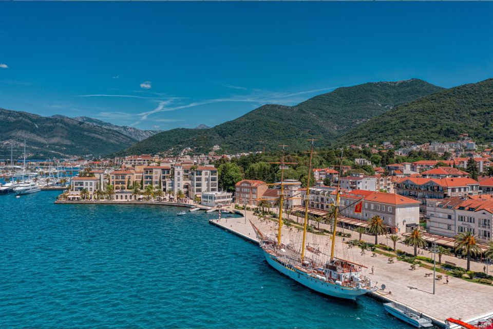 The view of Tivat waterfront, a luxurious coastal town with modern shopping, local professional football team, and clear waters.