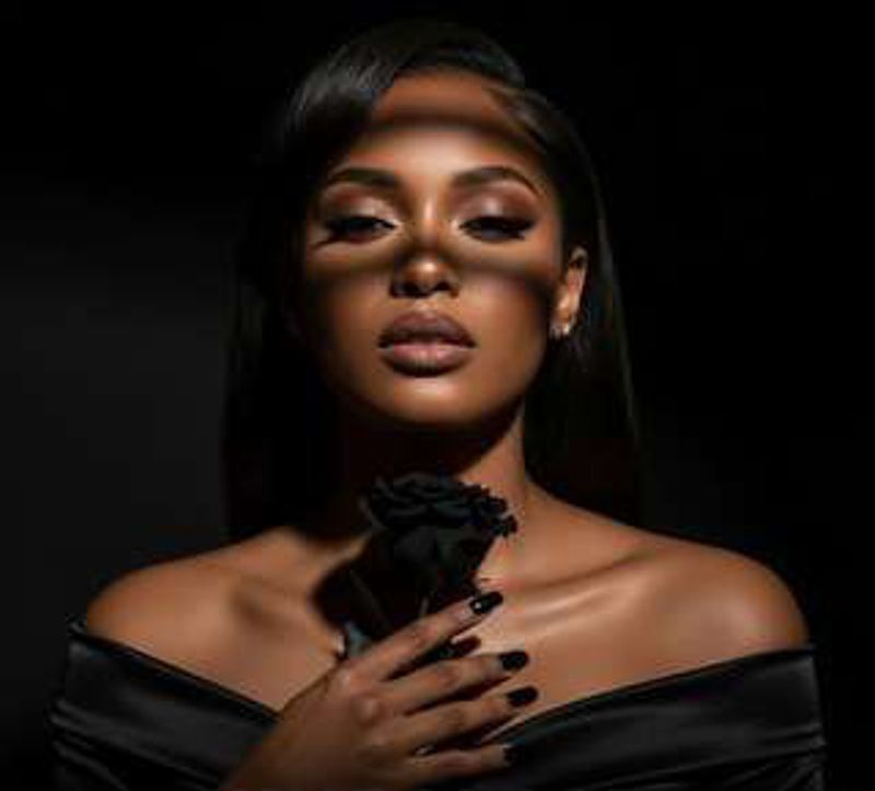 Album cover portrait of Xania Monet, an AI-generated singer, in an off-the-shoulder black top holding a black rose.
