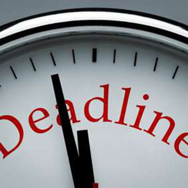 A clock face with the word “Deadline” printed on it, its hands just before twelve.