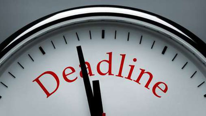 A clock face with the word “Deadline” printed on it, its hands just before twelve.