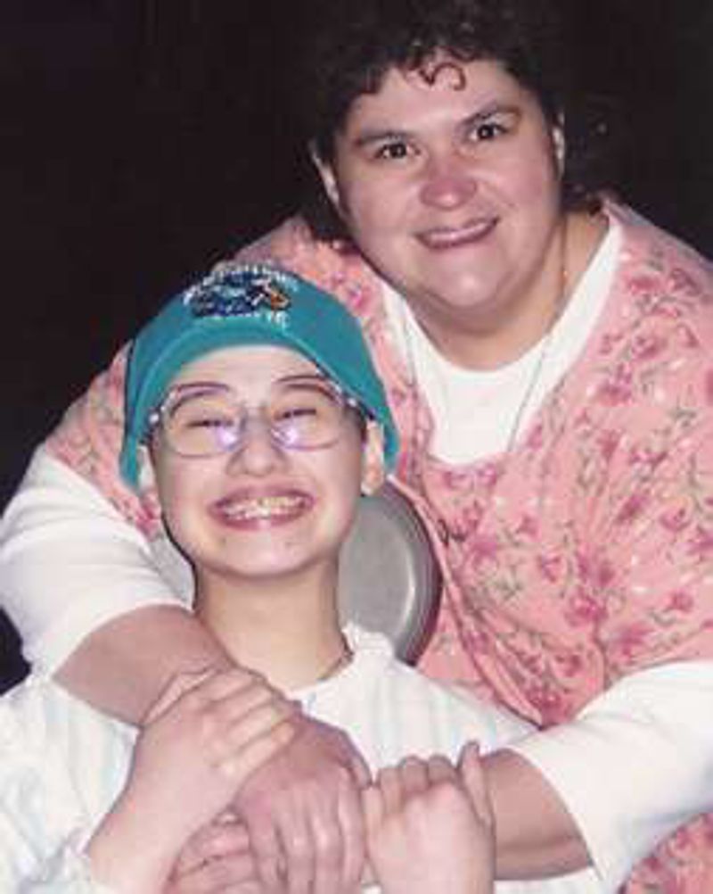 Dee Dee Blanchard hugs her young daughter Gypsy Rose, who wears glasses and a cap.
