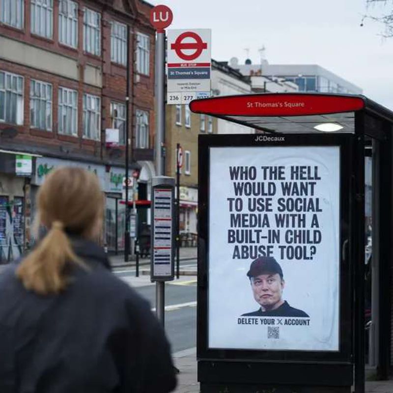 A woman walks past a London bus stop poster of Elon Musk reading “Who the hell would want to use social media with a built-in child abuse tool?”