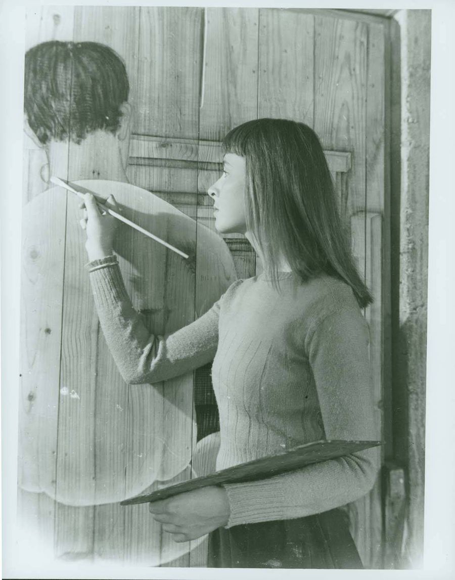 Faith Murray painting door to weaving room.