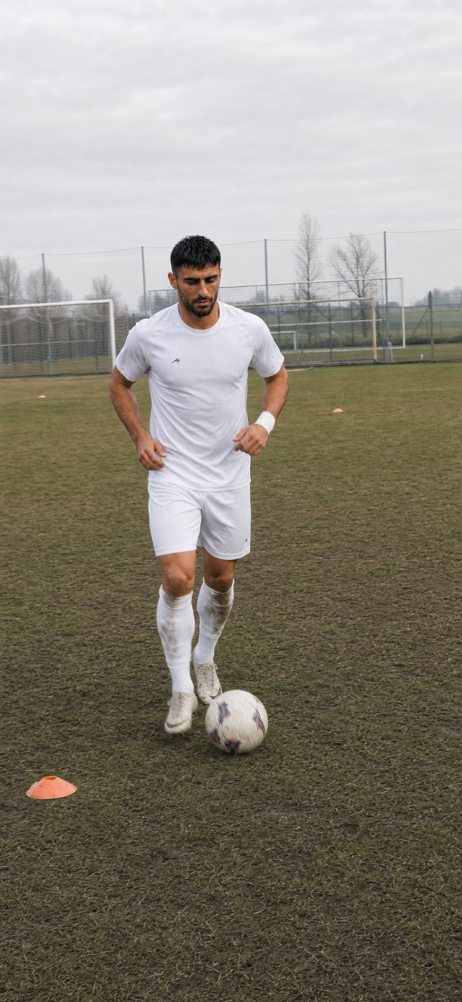 A male AI creator training alone on a football pitch