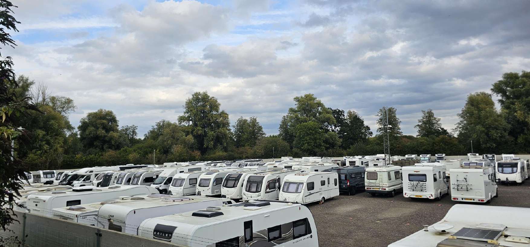 Rows of caravans and motorhomes on the hardstanding, with the CCTV mast behind