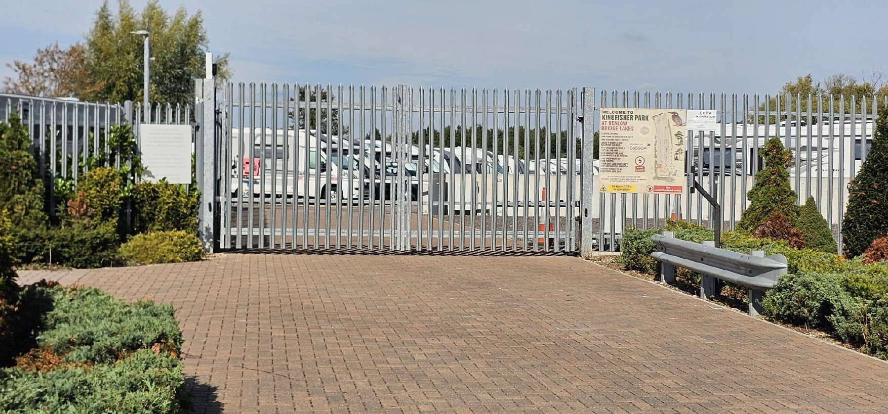 The palisade entrance gates and the Kingfisher Park welcome sign