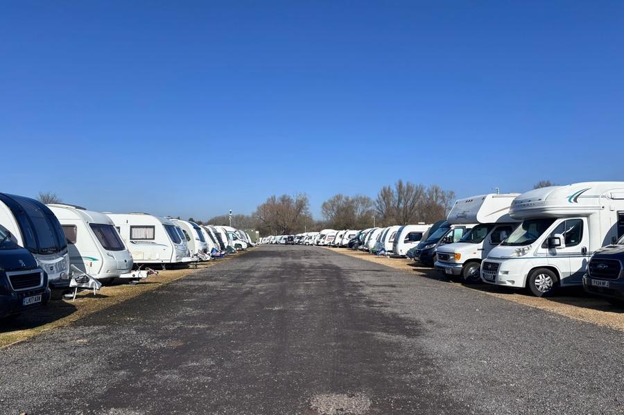 Touring caravans and motorhomes parked in rows on level hardstanding