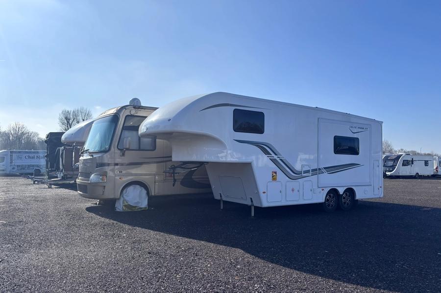 A large American-style RV stored alongside touring caravans