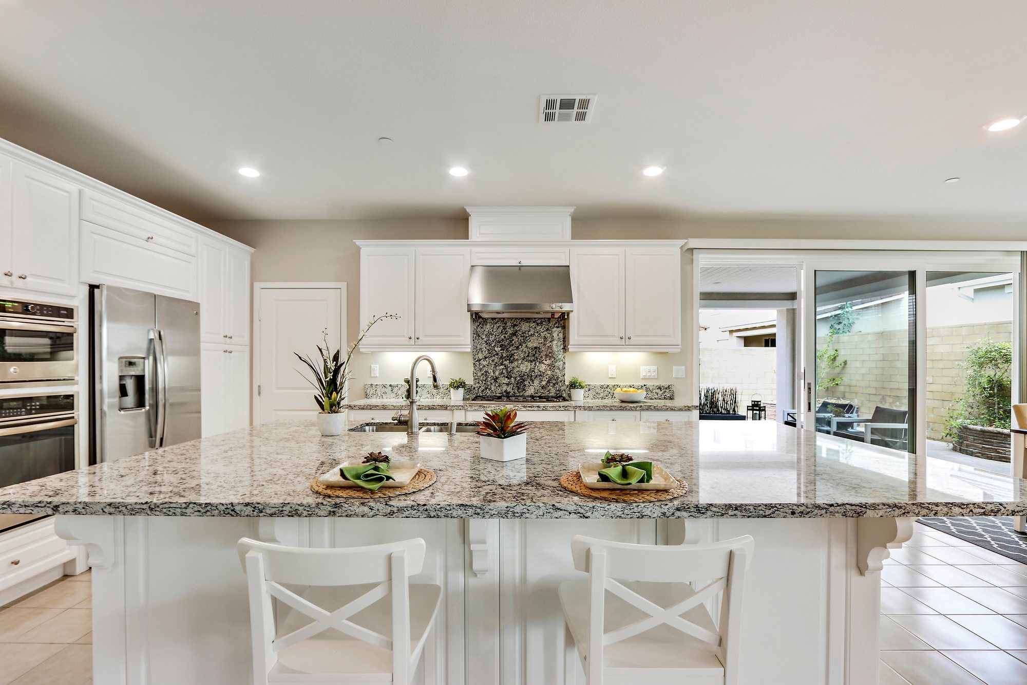 Kitchen with a granite island, white cabinets and stainless appliances, Irvine