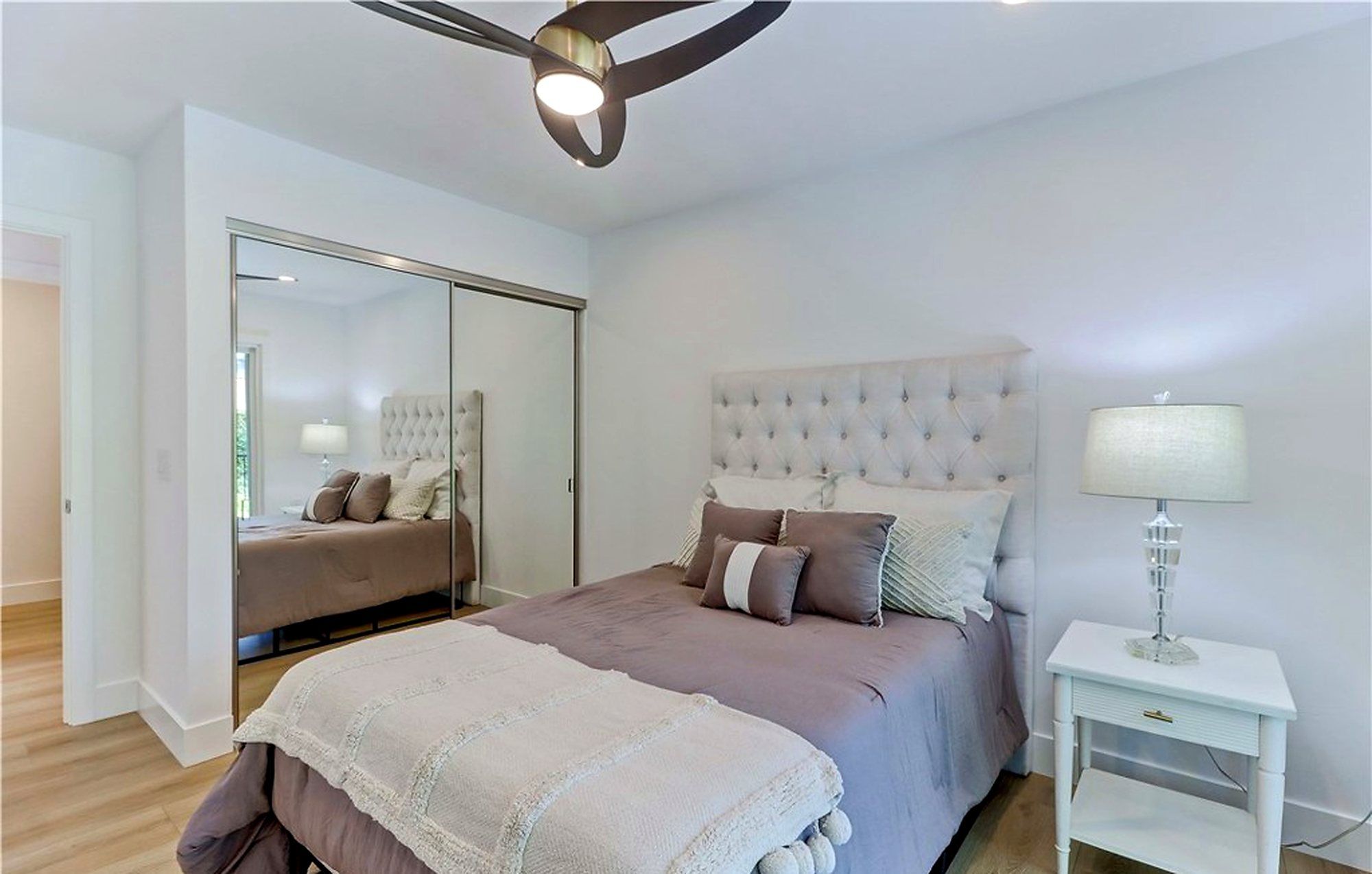 Bed with a tufted headboard beside a mirrored closet, Laguna Woods