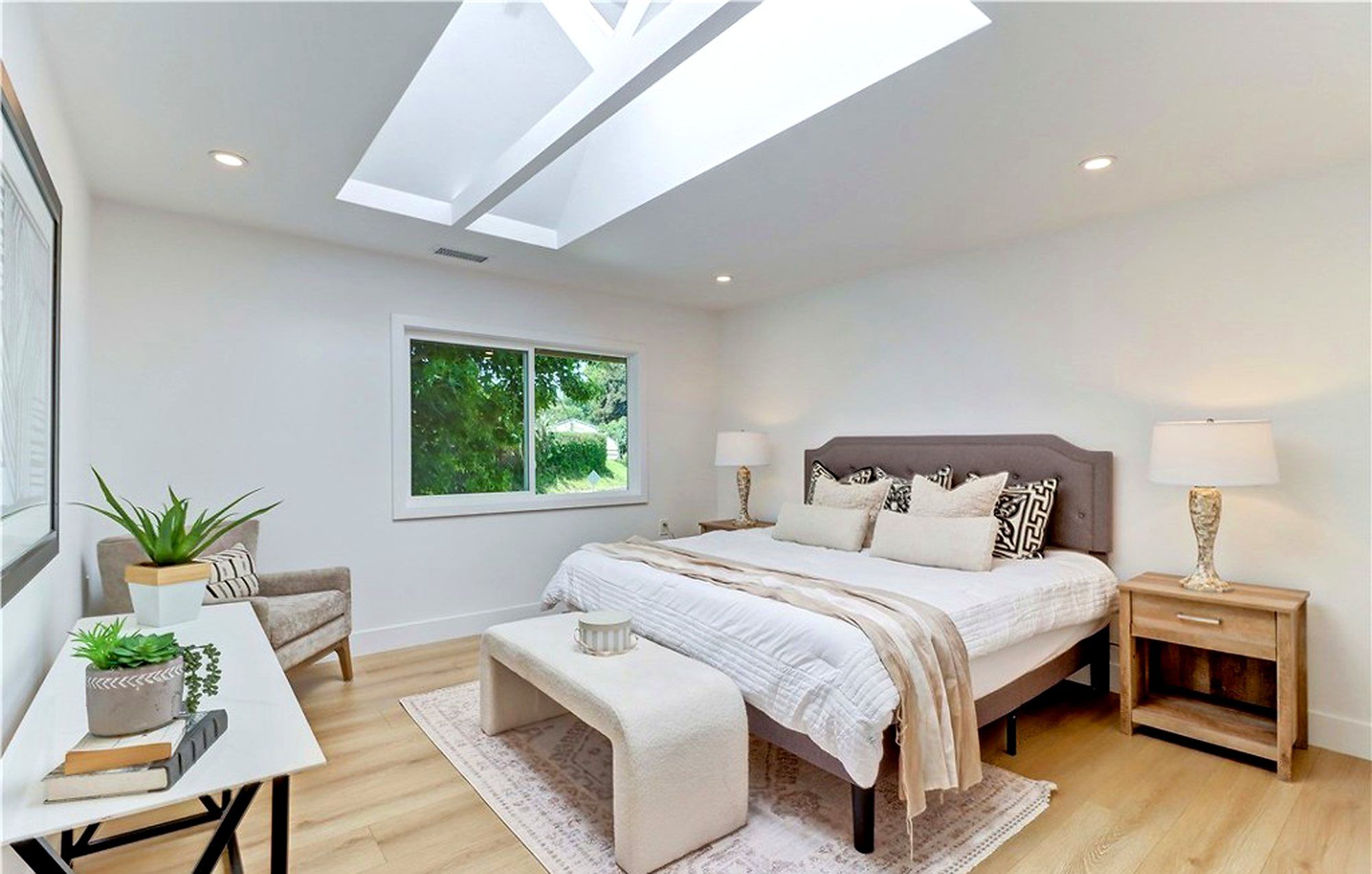 Primary bedroom with a bench at the foot of the bed, under a skylight, Laguna Woods