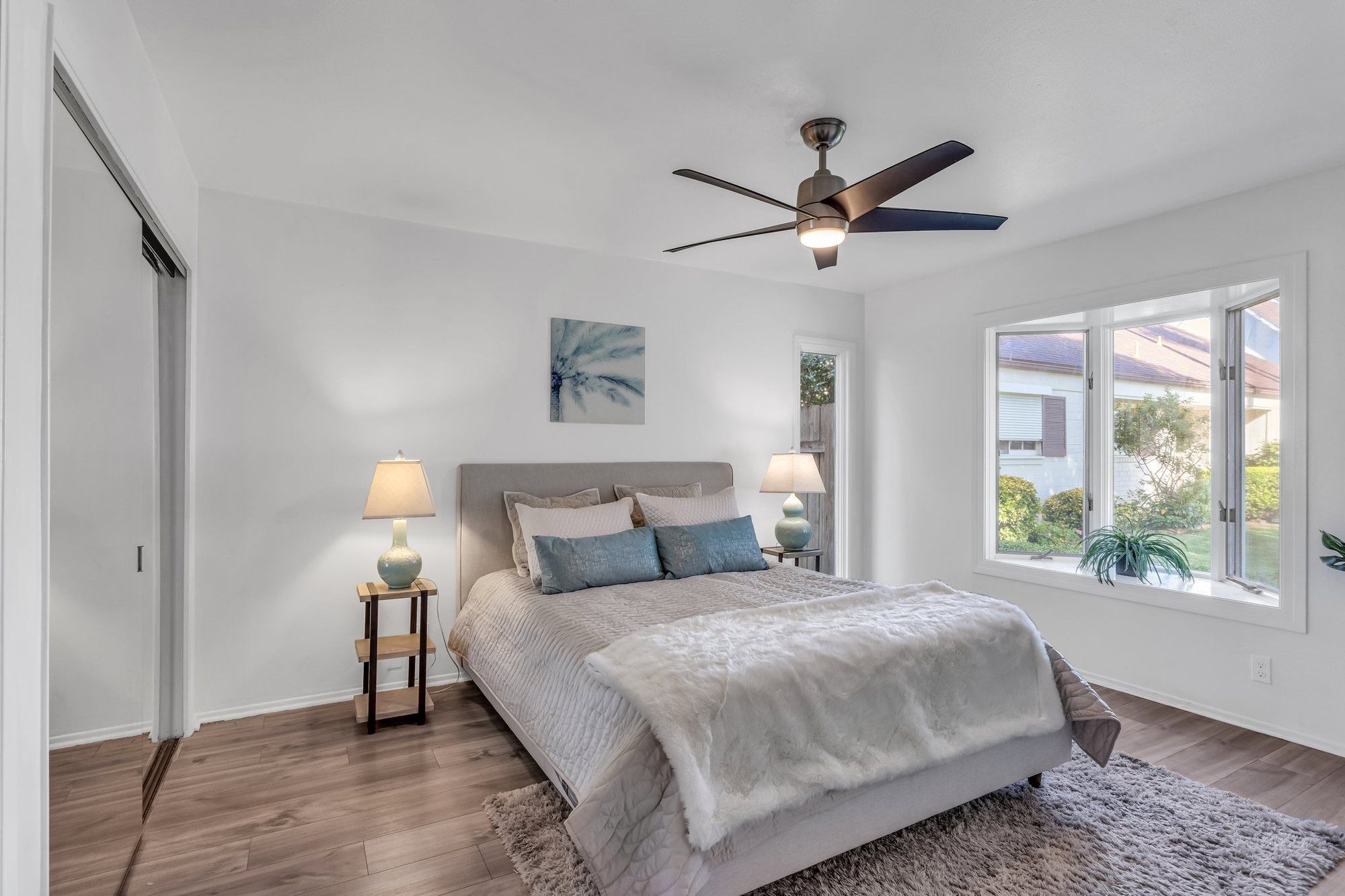 Bedroom with a gray upholstered bed and blue pillows, Tustin