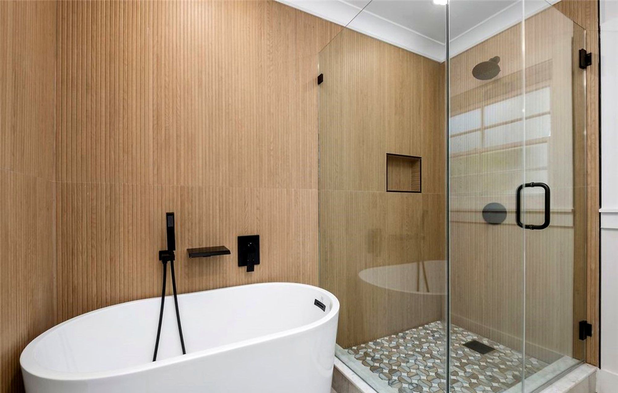 Freestanding tub beside a glass-enclosed shower, Santa Ana