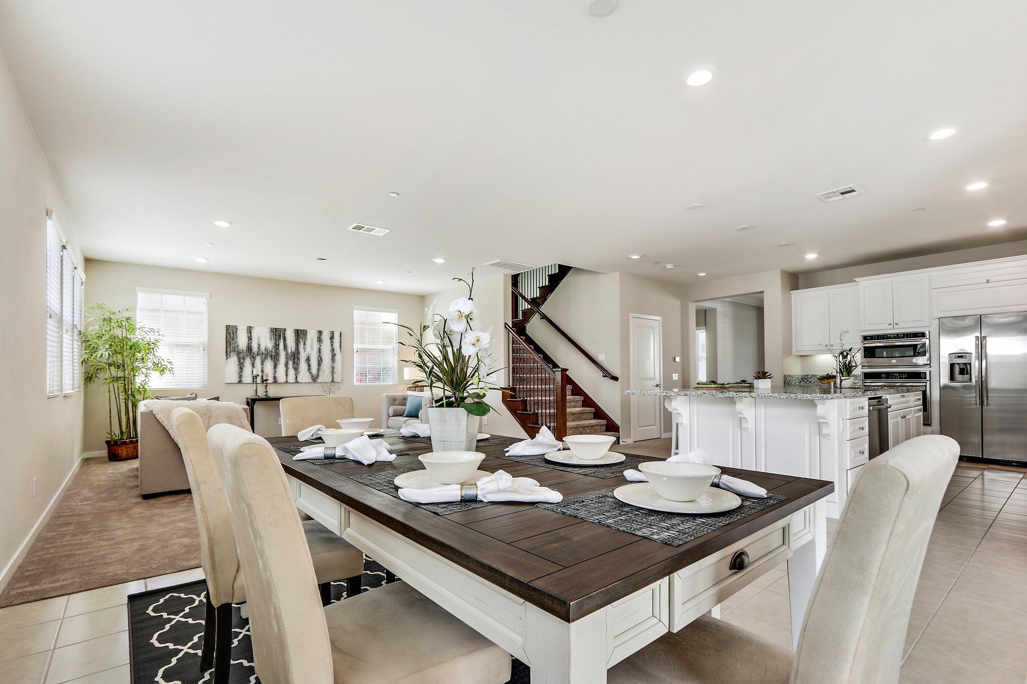 Dining table set for six, with the kitchen and staircase beyond, Irvine