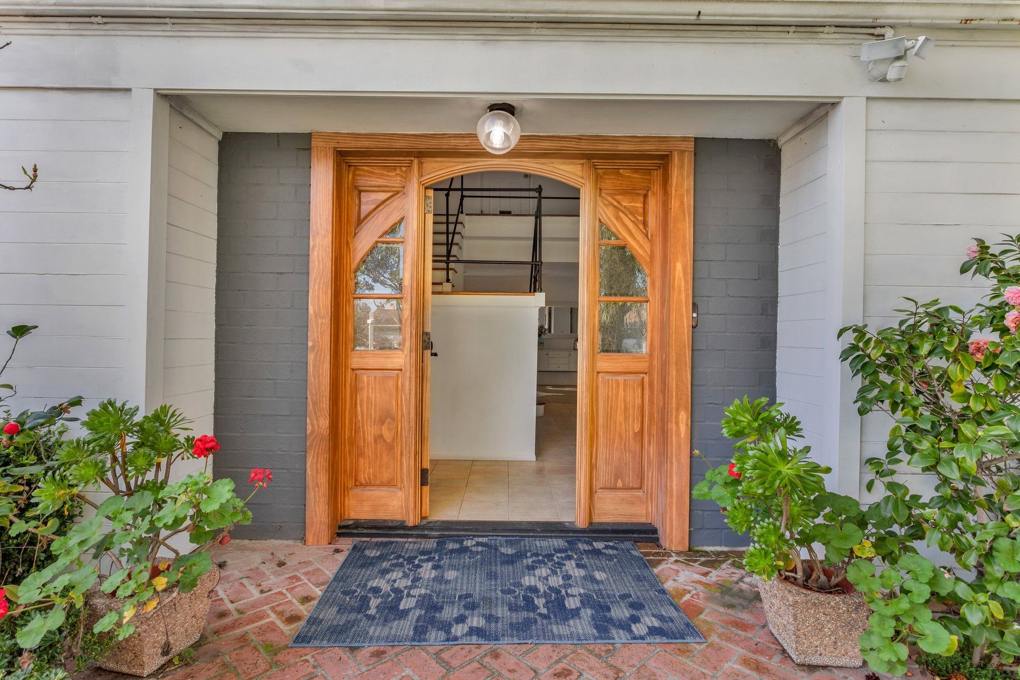 Wood front door with potted geraniums, Tustin