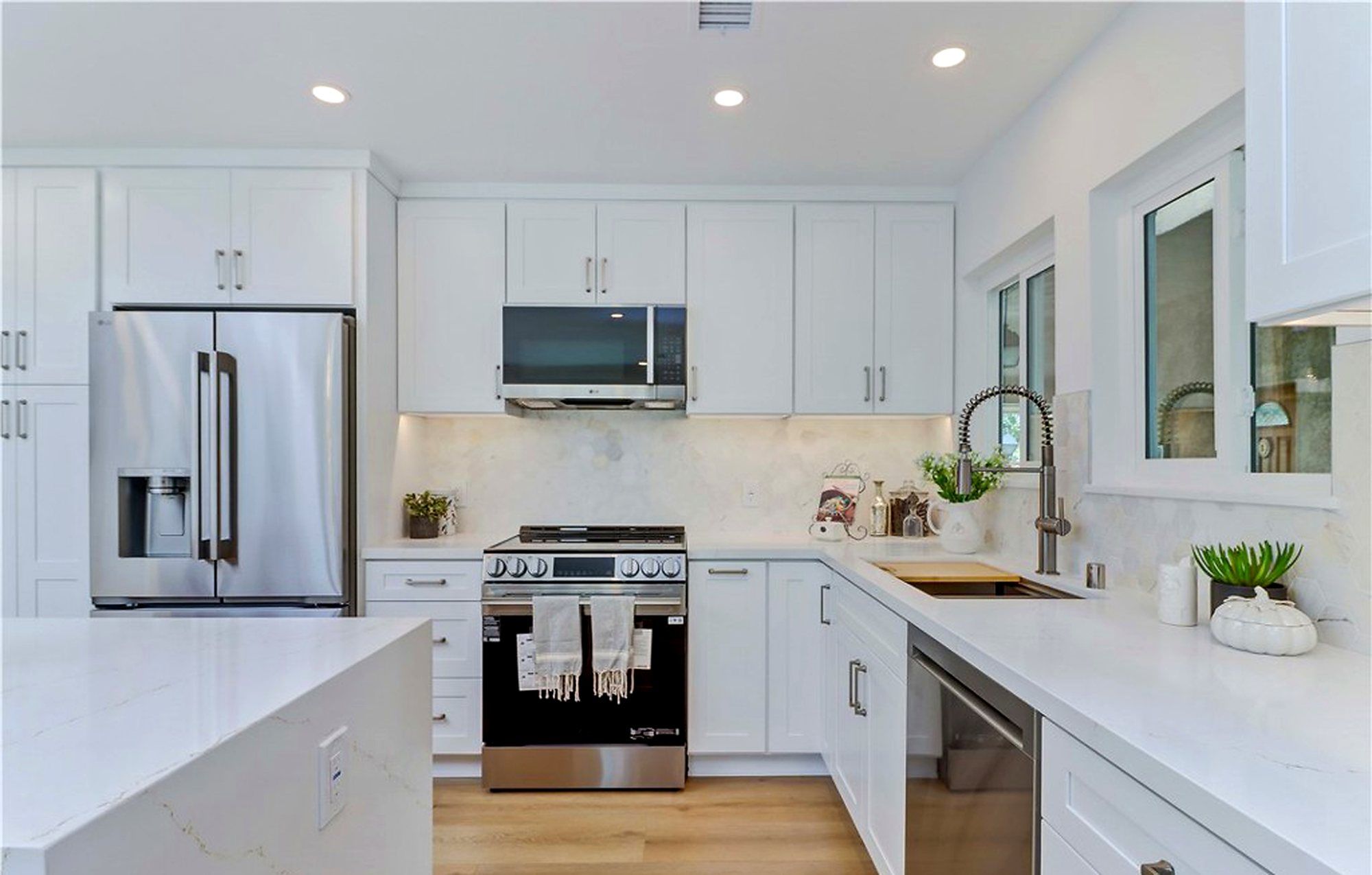White kitchen with a stainless range and quartz counters, Laguna Woods