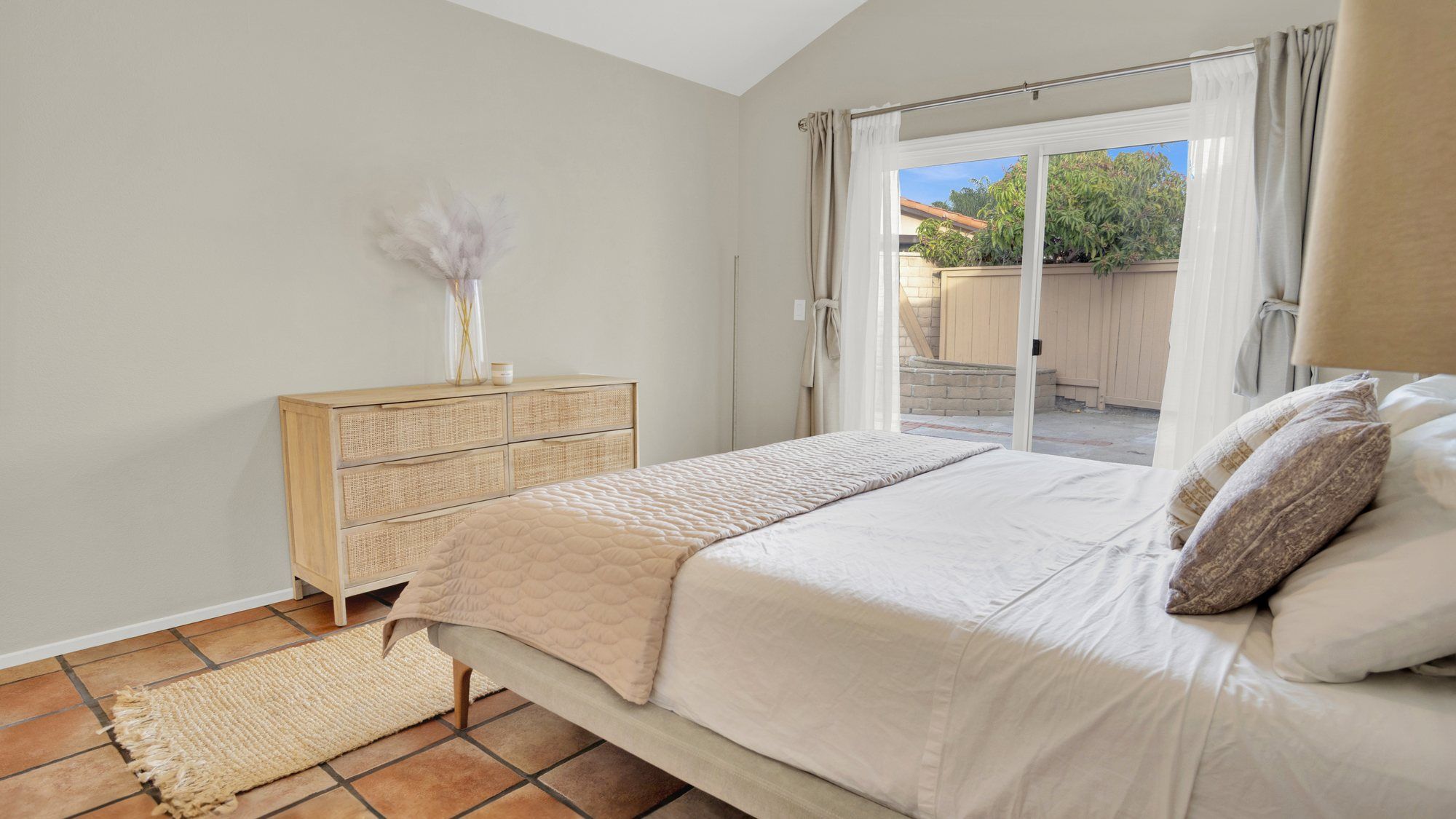 Bedroom with neutral bedding and a sliding door to the yard, Dana Point