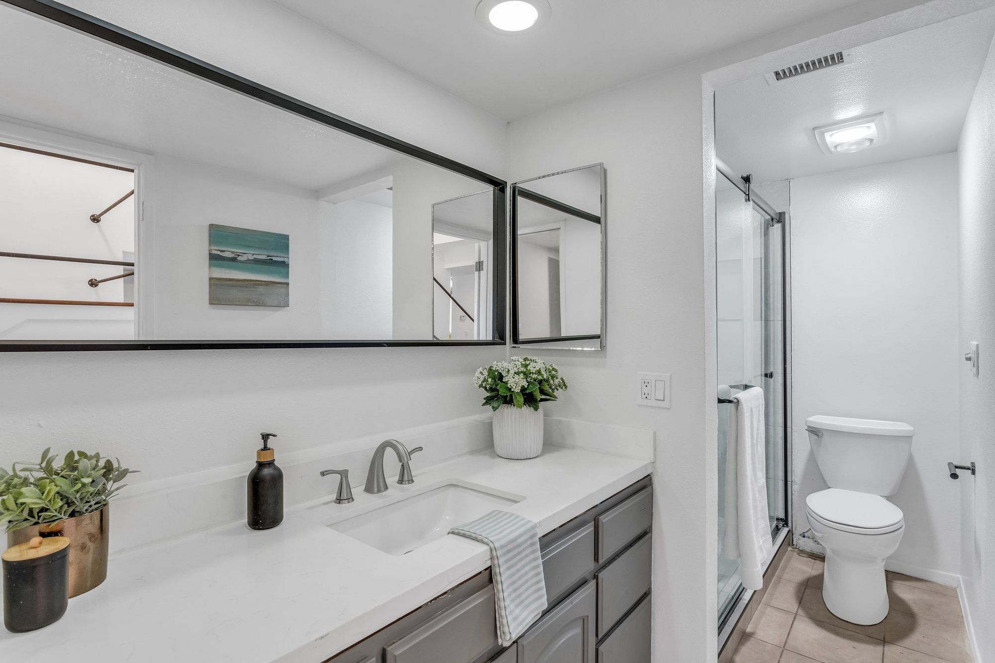 Bathroom with a gray vanity and a black-framed mirror, Tustin