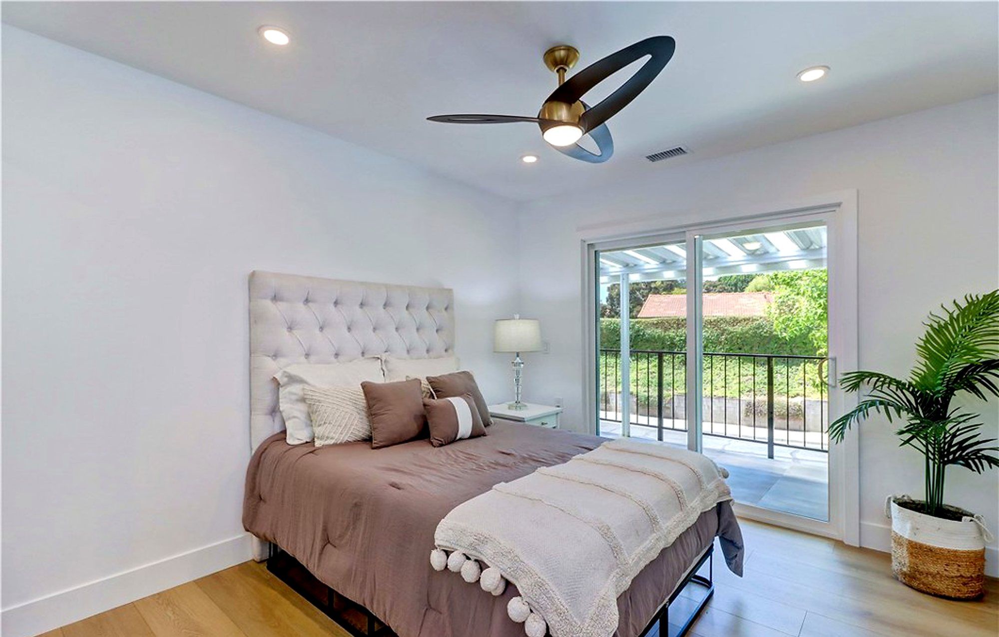 Bedroom with a tufted headboard, mauve bedding and a sliding door, Laguna Woods