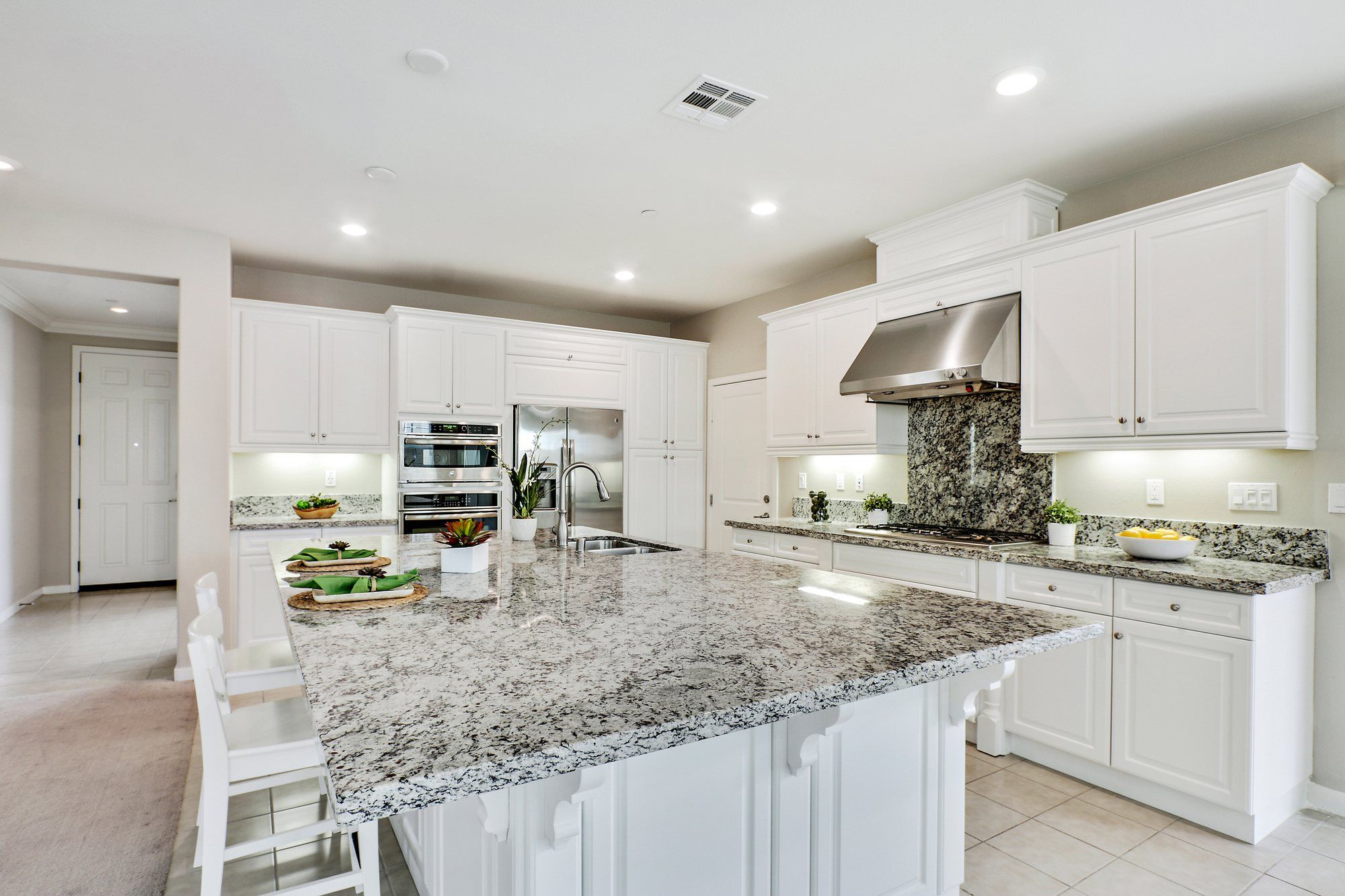 Granite island set with green placemats, Irvine