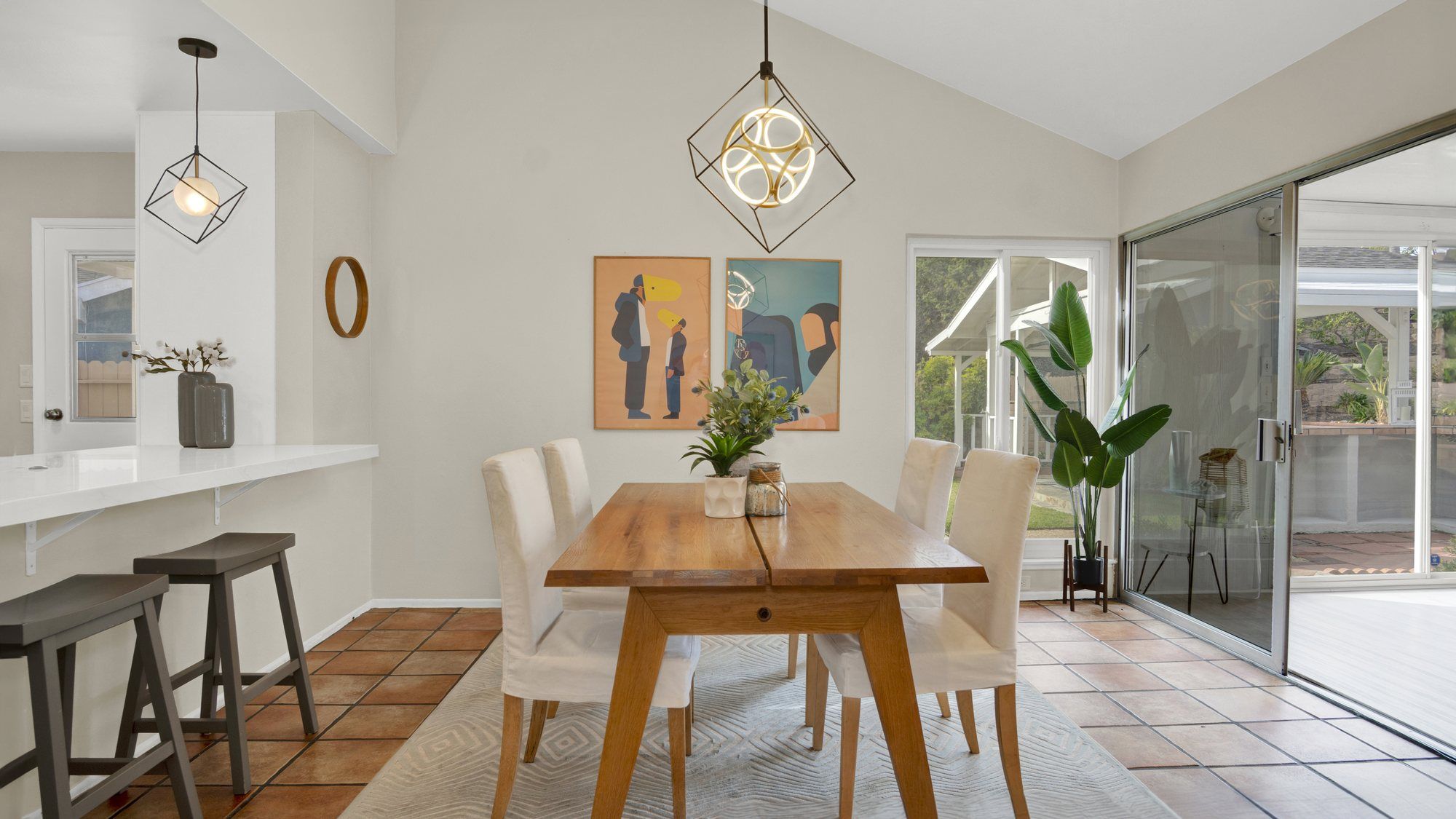 Wood dining table with white chairs beside a sliding door, Dana Point