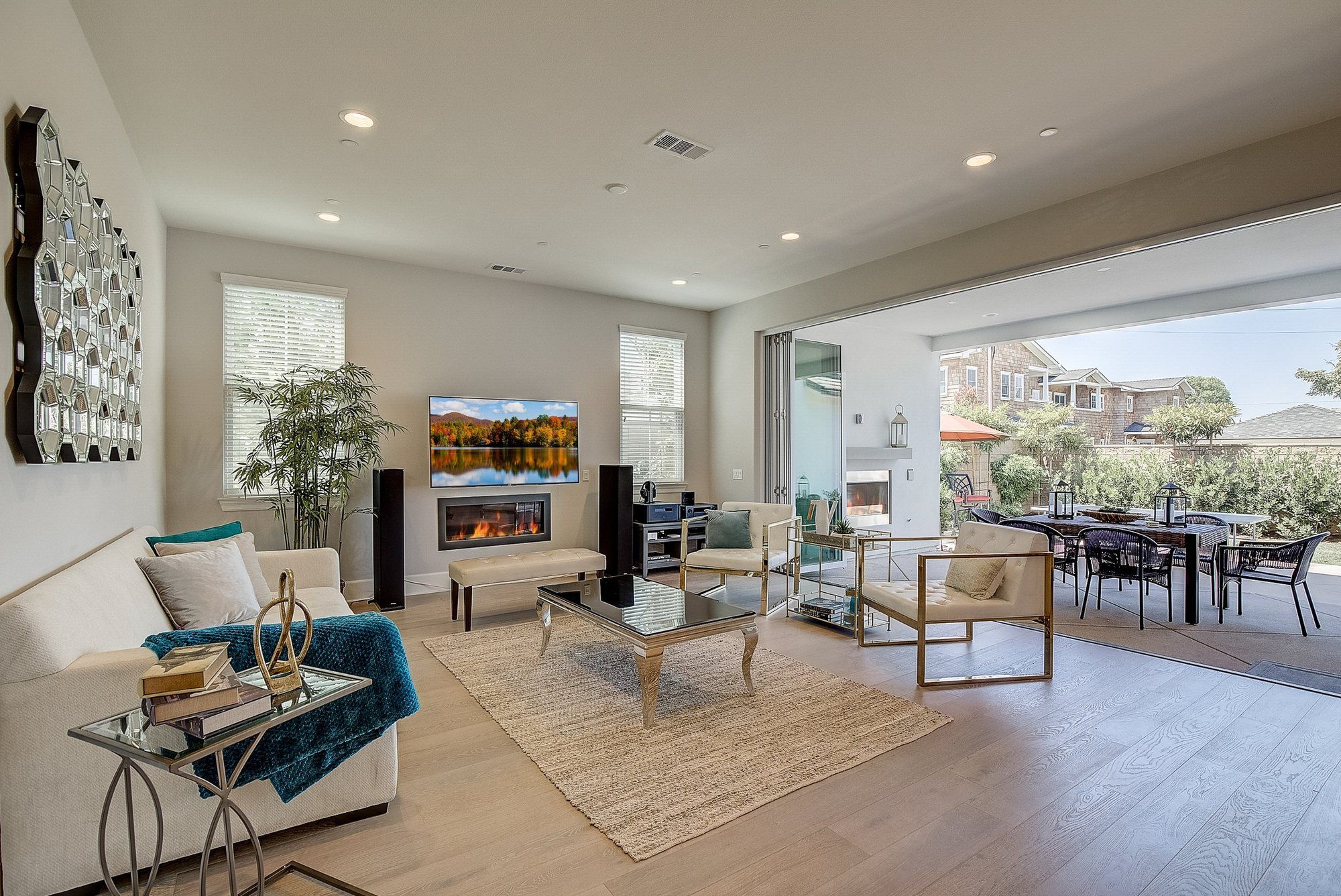 Great room with white seating and a glass coffee table, open to the patio, Costa Mesa