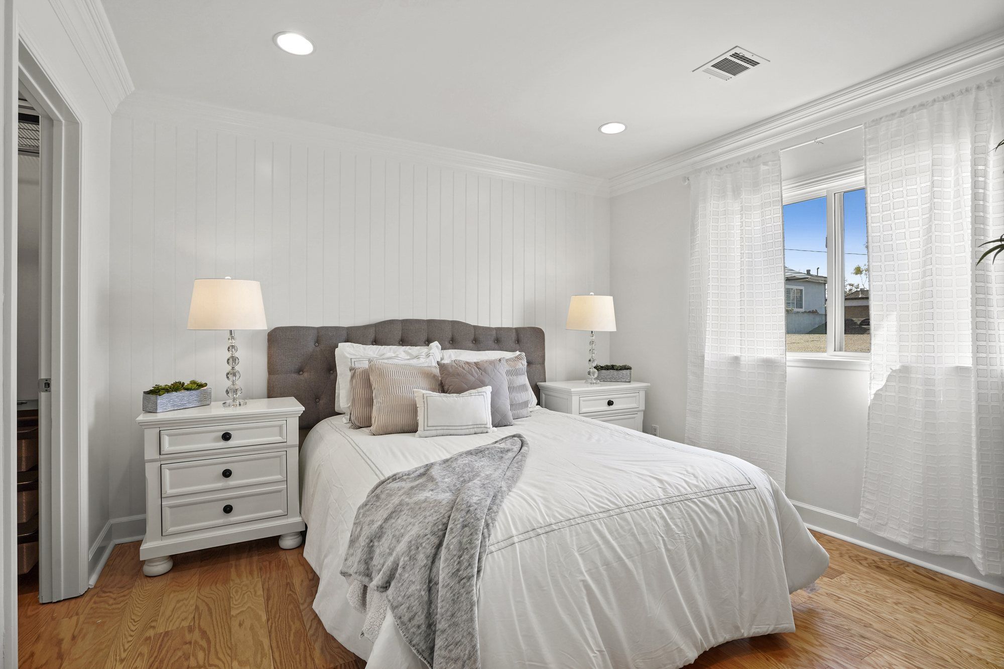 Bedroom with a tufted gray headboard and white bedding, Newport Beach