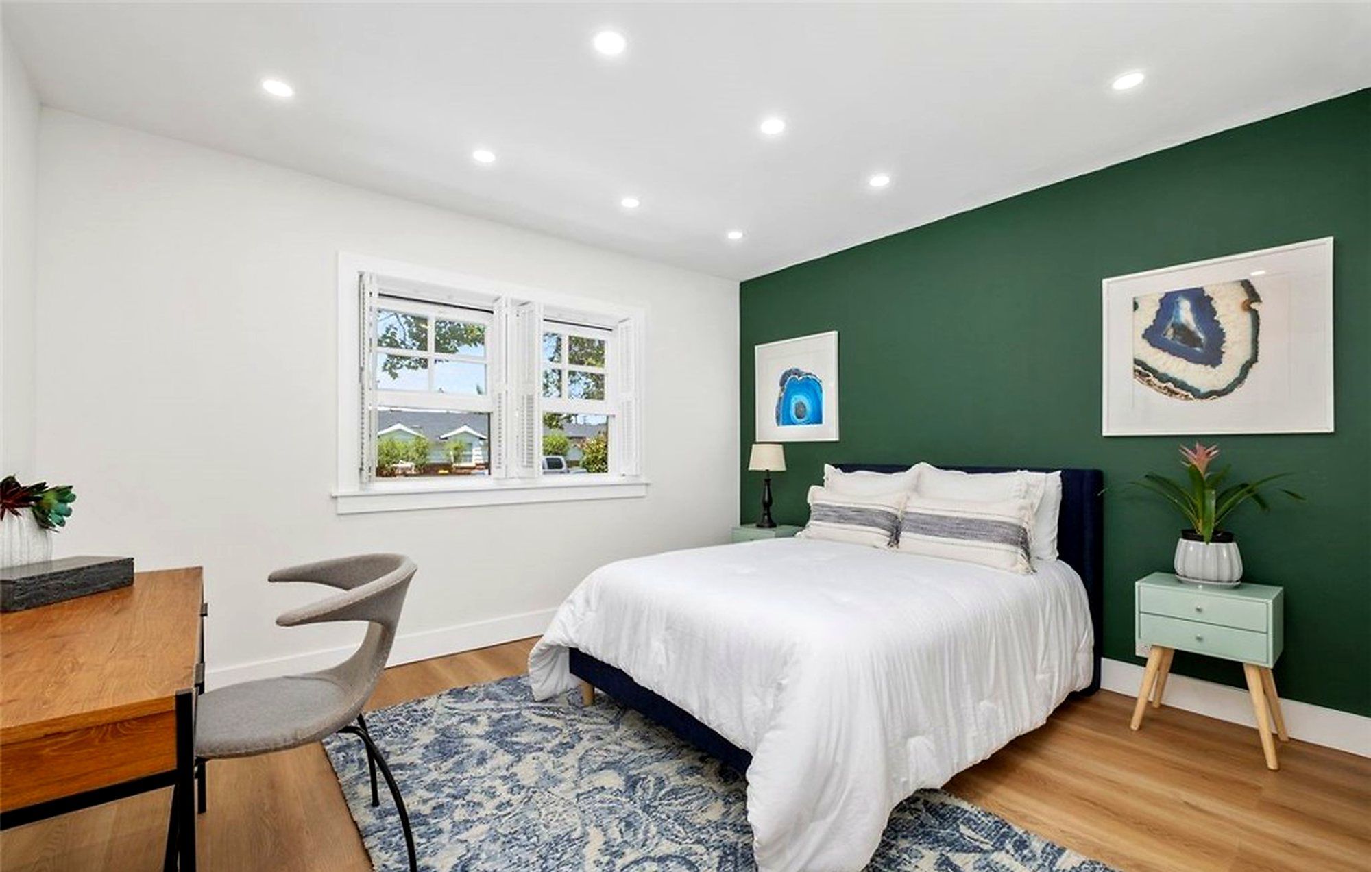 Bedroom with white bedding against a dark green accent wall, Santa Ana