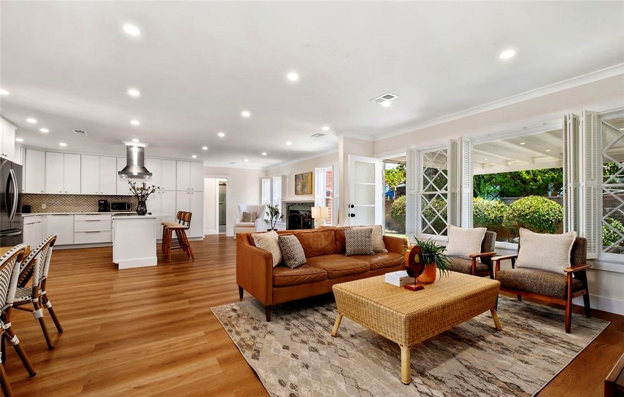 Open living area with a tan leather sofa and a woven coffee table, Santa Ana