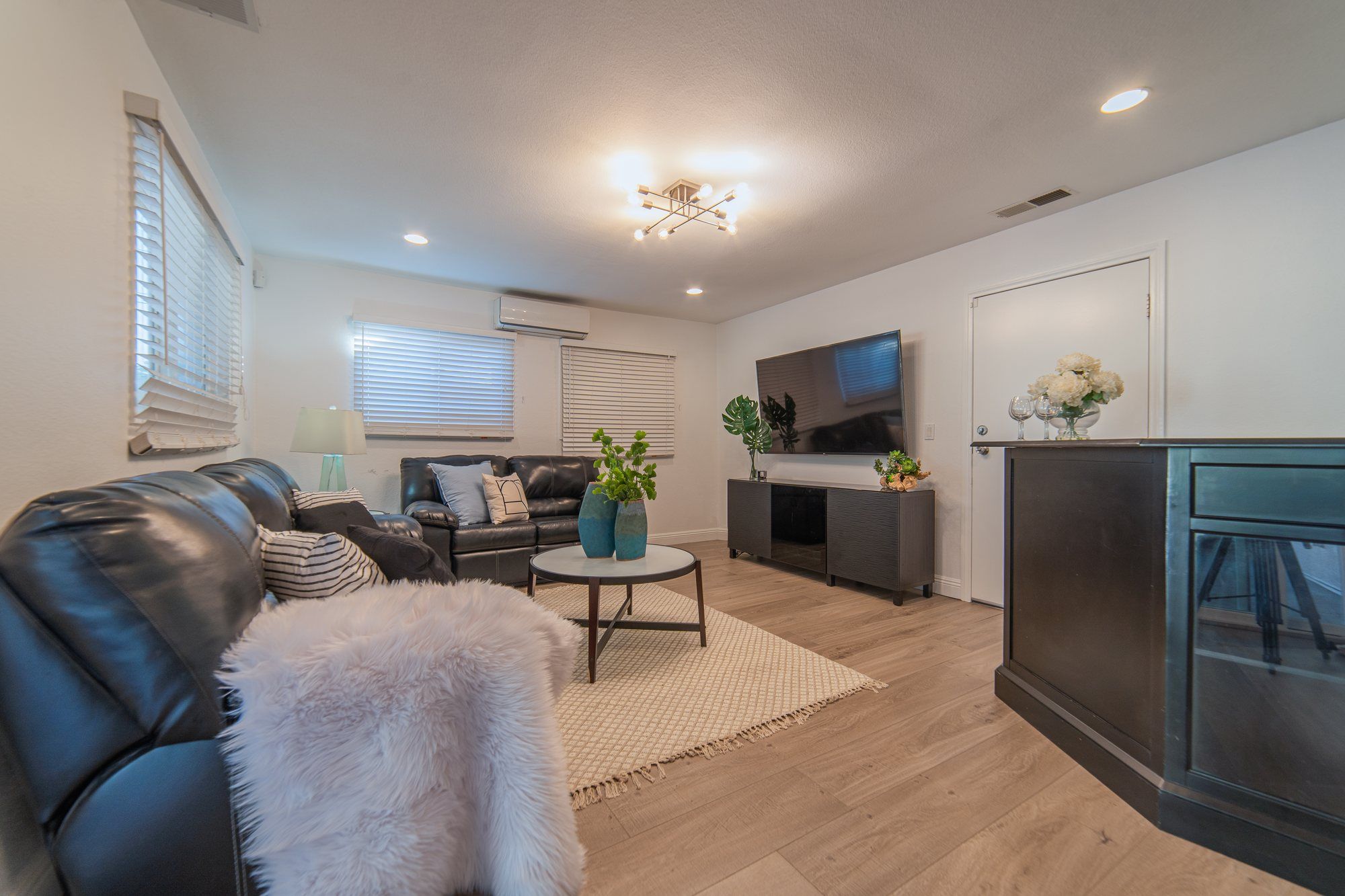 Family room with a black leather sectional and a media console, Anaheim