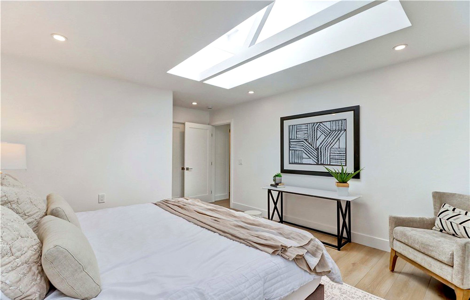 Primary bed facing a console and framed art, Laguna Woods