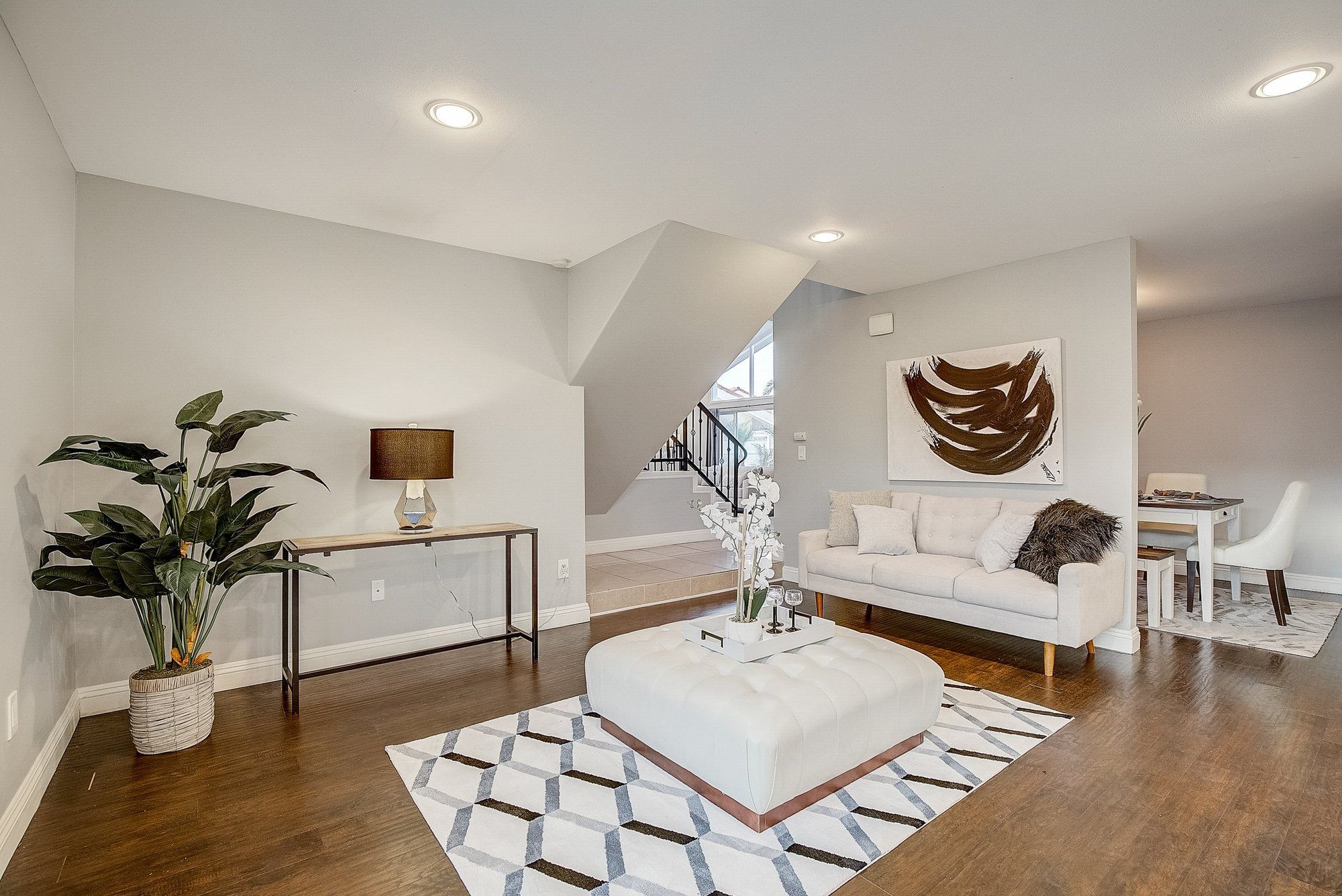 Sitting room with a white tufted ottoman on a geometric rug, Huntington Beach