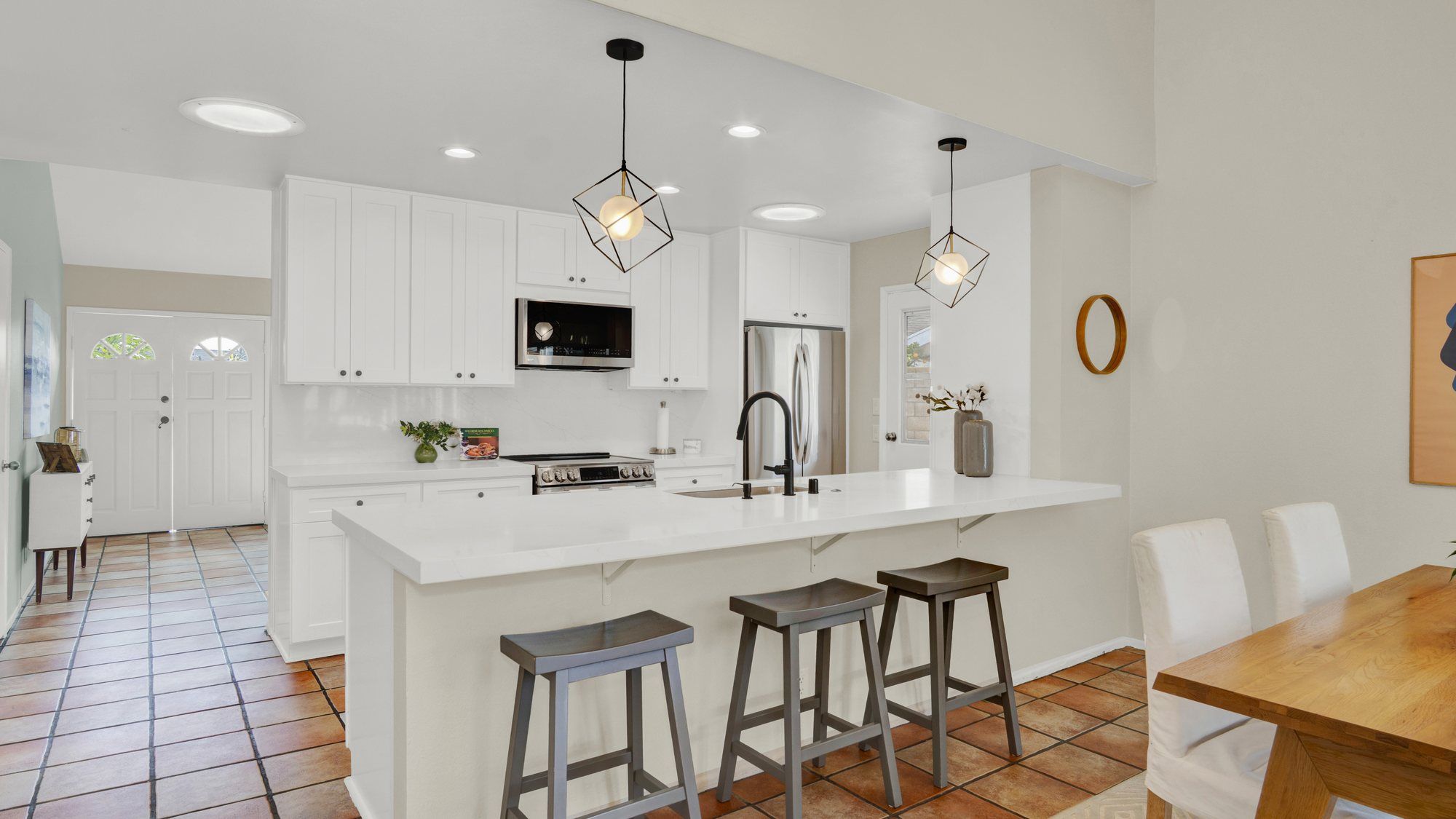 Kitchen counter with three gray stools next to the dining table, Dana Point