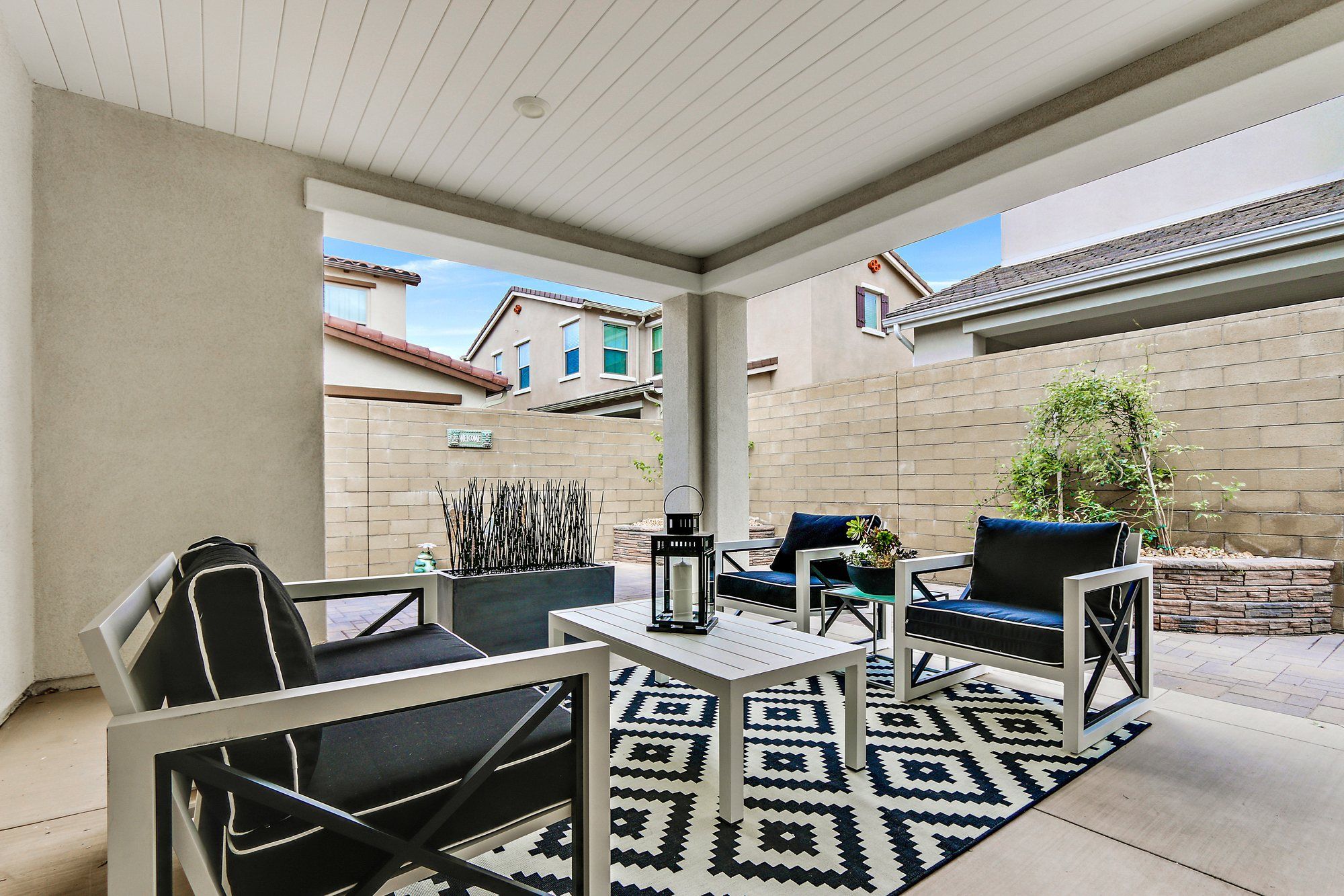Covered patio with black-and-white seating on a geometric rug, Irvine