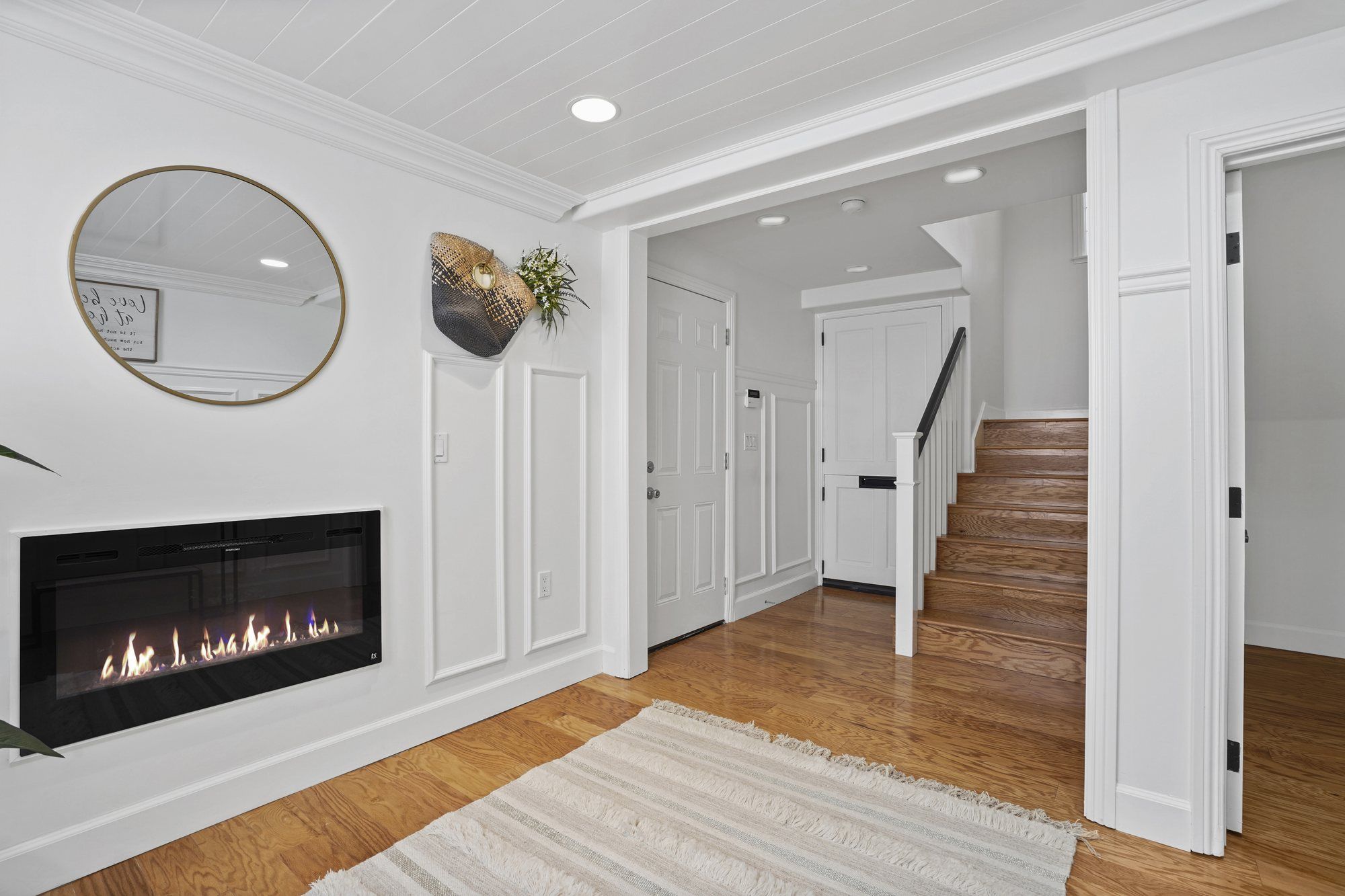 Landing with a linear electric fireplace and a round mirror, Newport Beach