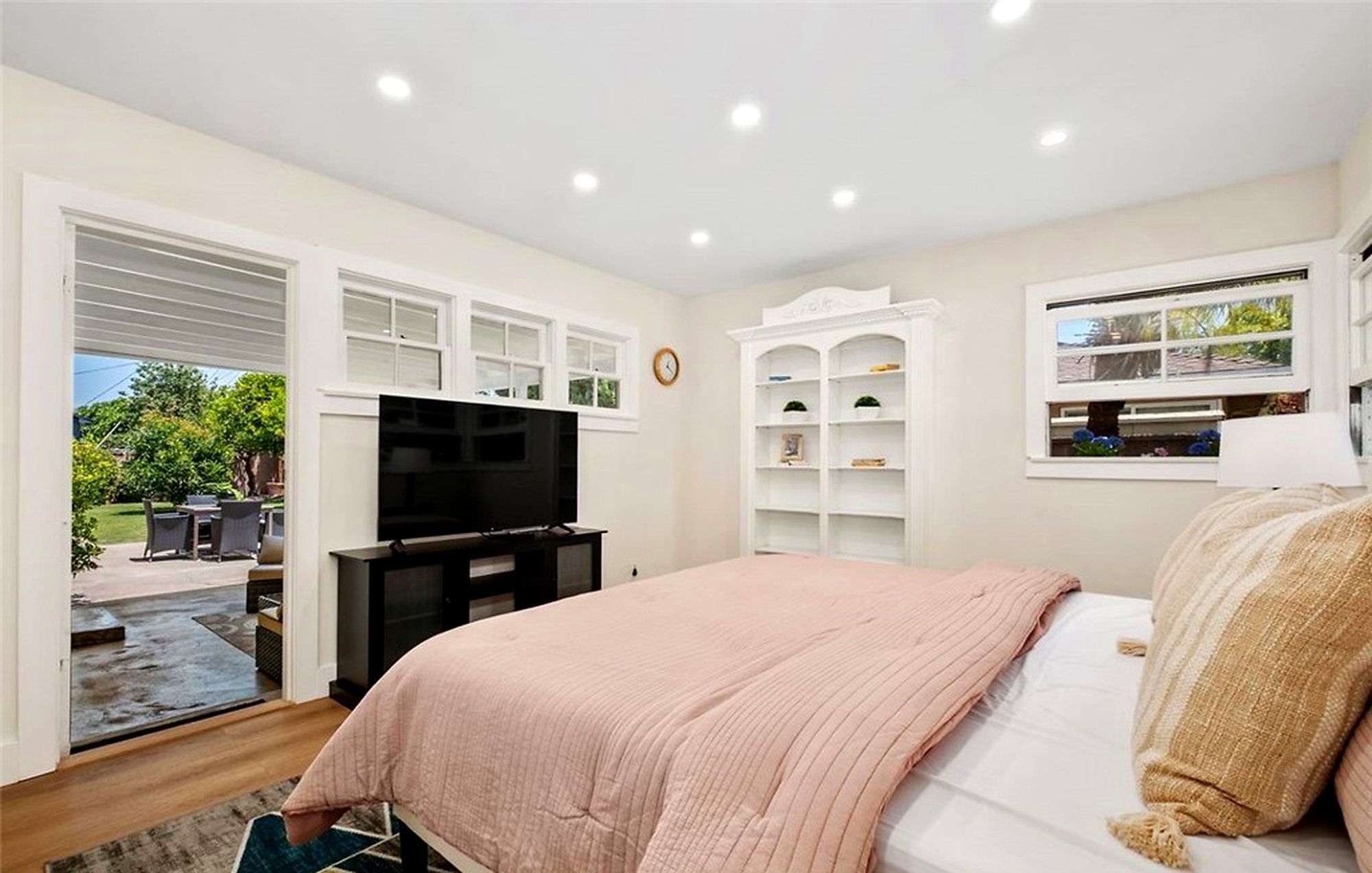 Bed with blush bedding facing a window onto the yard, Santa Ana