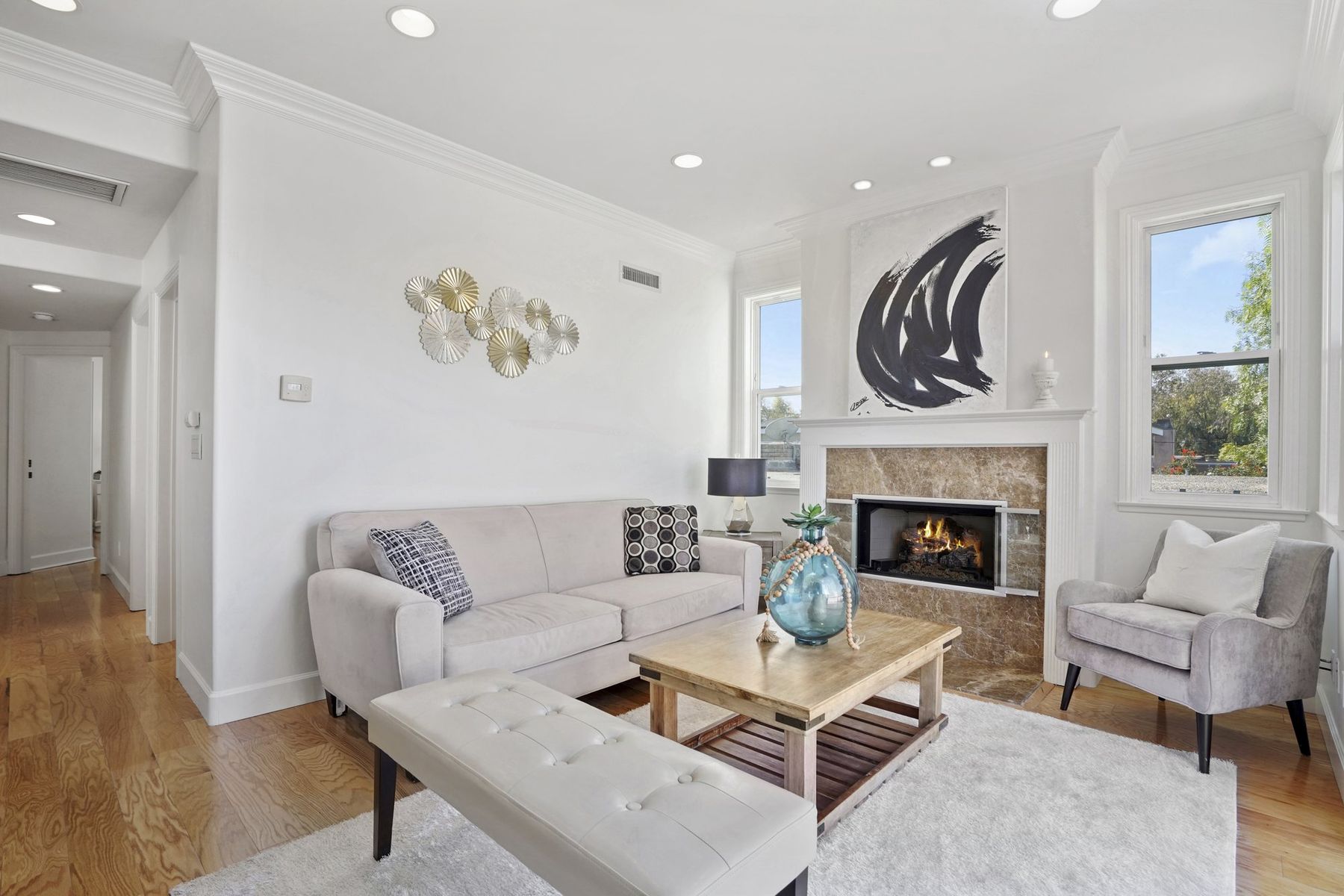 A staged living room with a cream sofa and a tufted bench