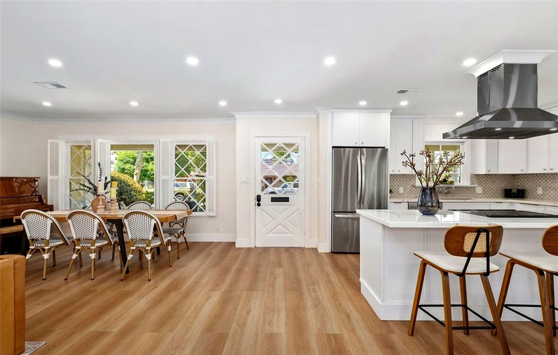 A staged kitchen island with wood stools beside the dining table