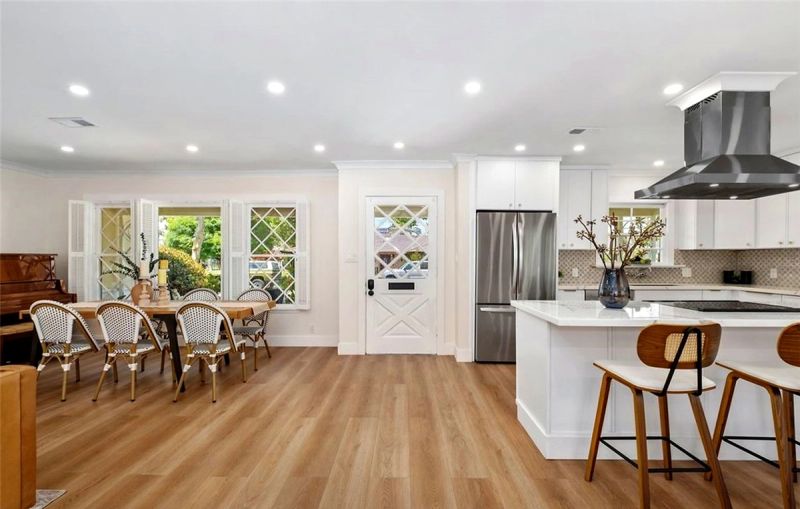 A staged Santa Ana kitchen island with wood stools beside a dining table