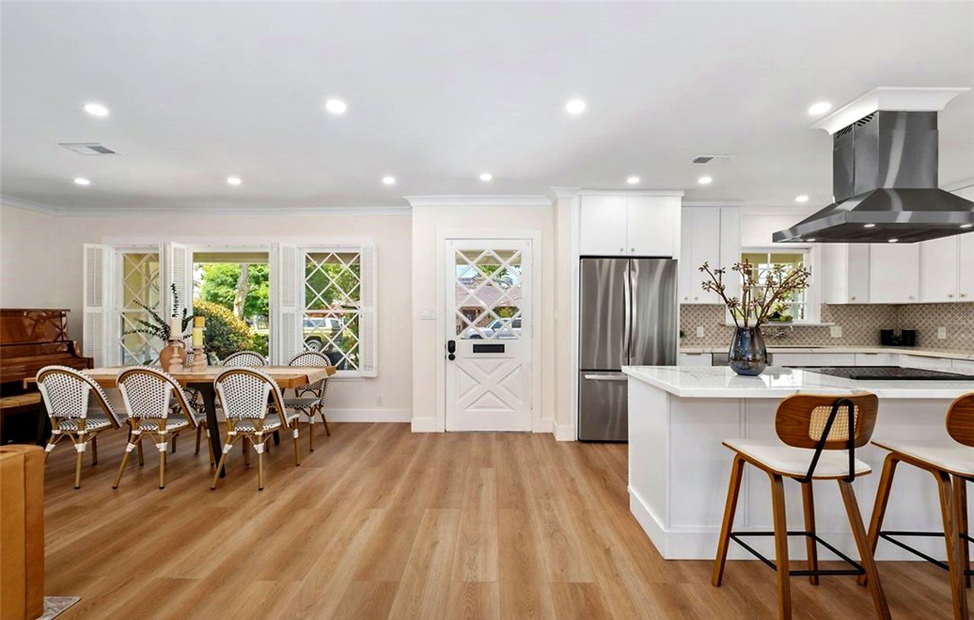 Kitchen island with wood stools beside a dining table with bistro chairs, Santa Ana