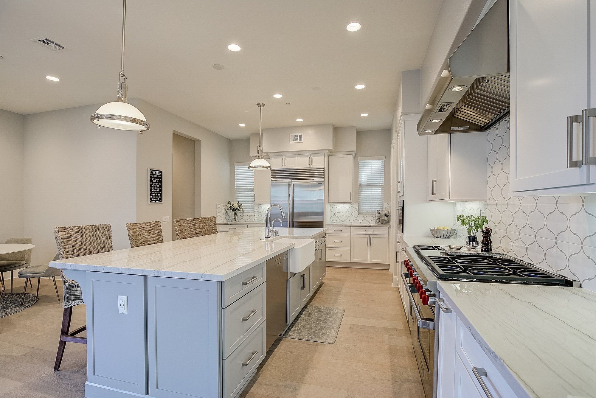 Kitchen with a large island, woven stools and pendant lights, Costa Mesa