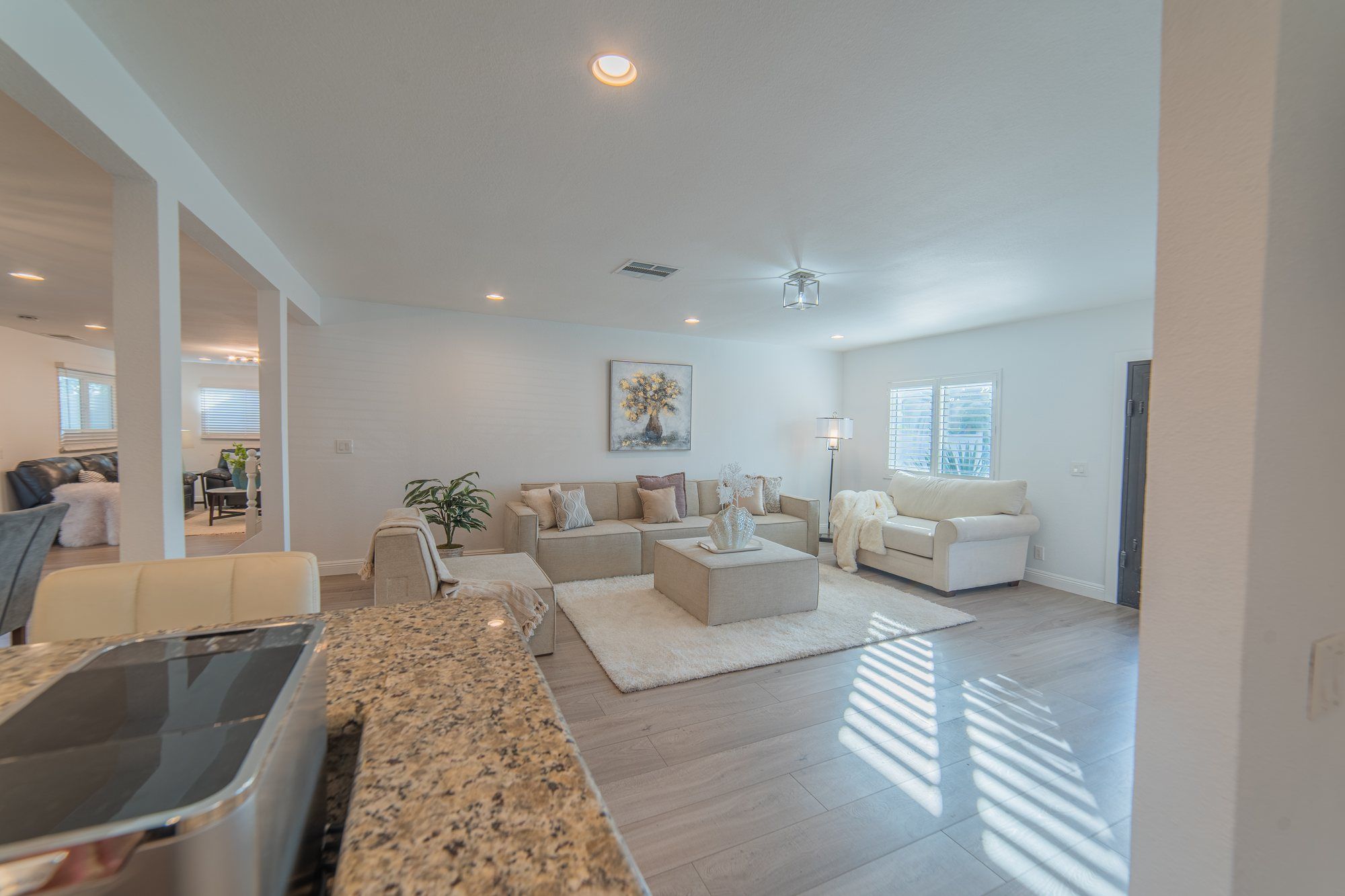 Open living room with cream sofas, seen from the kitchen, Anaheim