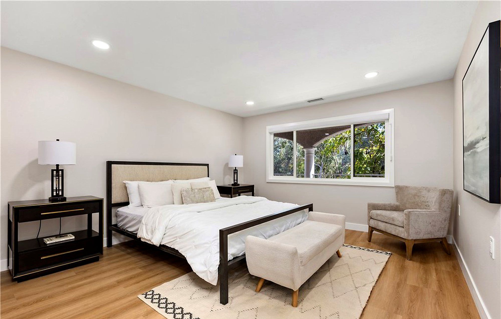 Bedroom with a black-framed bed, an upholstered bench and an armchair, Laguna Woods