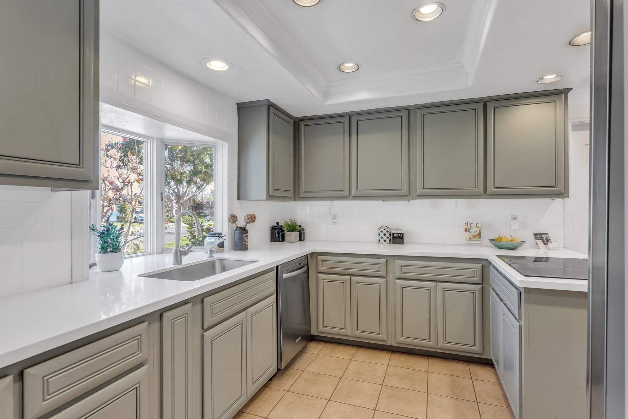Kitchen with sage-gray cabinets and white counters, Tustin
