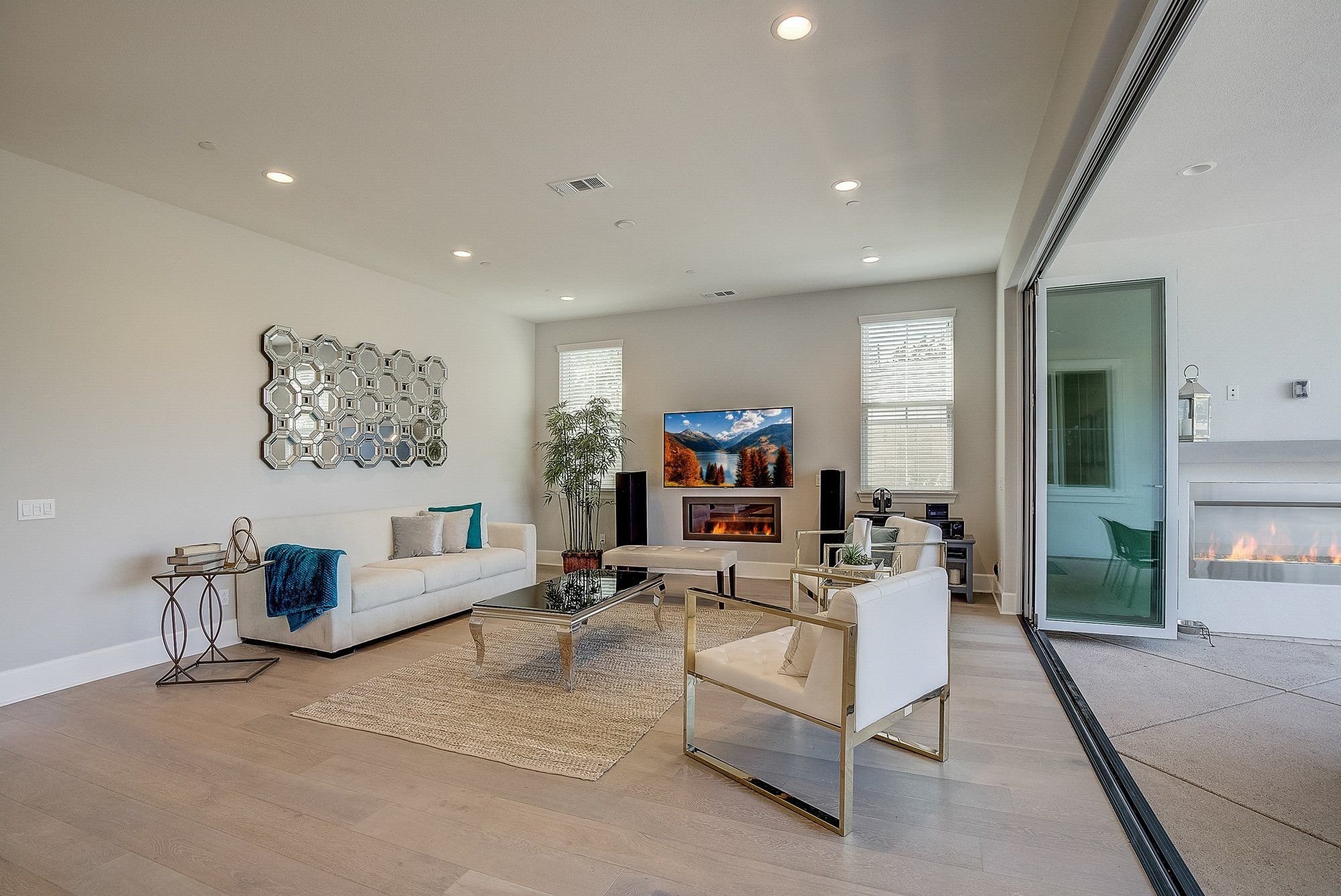 Great room with a mirrored wall sculpture and a fireplace, Costa Mesa