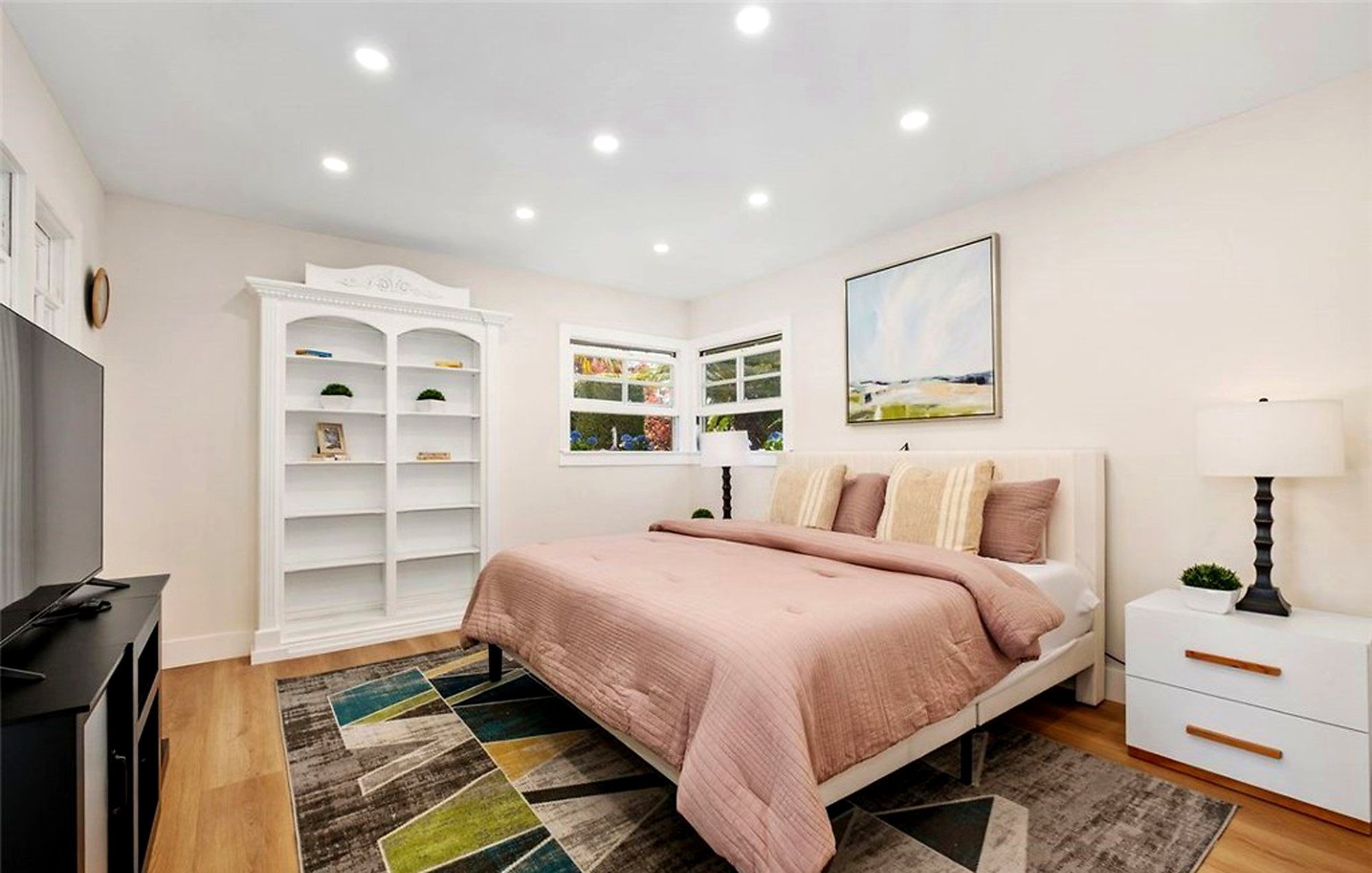 Bedroom with blush bedding and built-in white shelves, Santa Ana