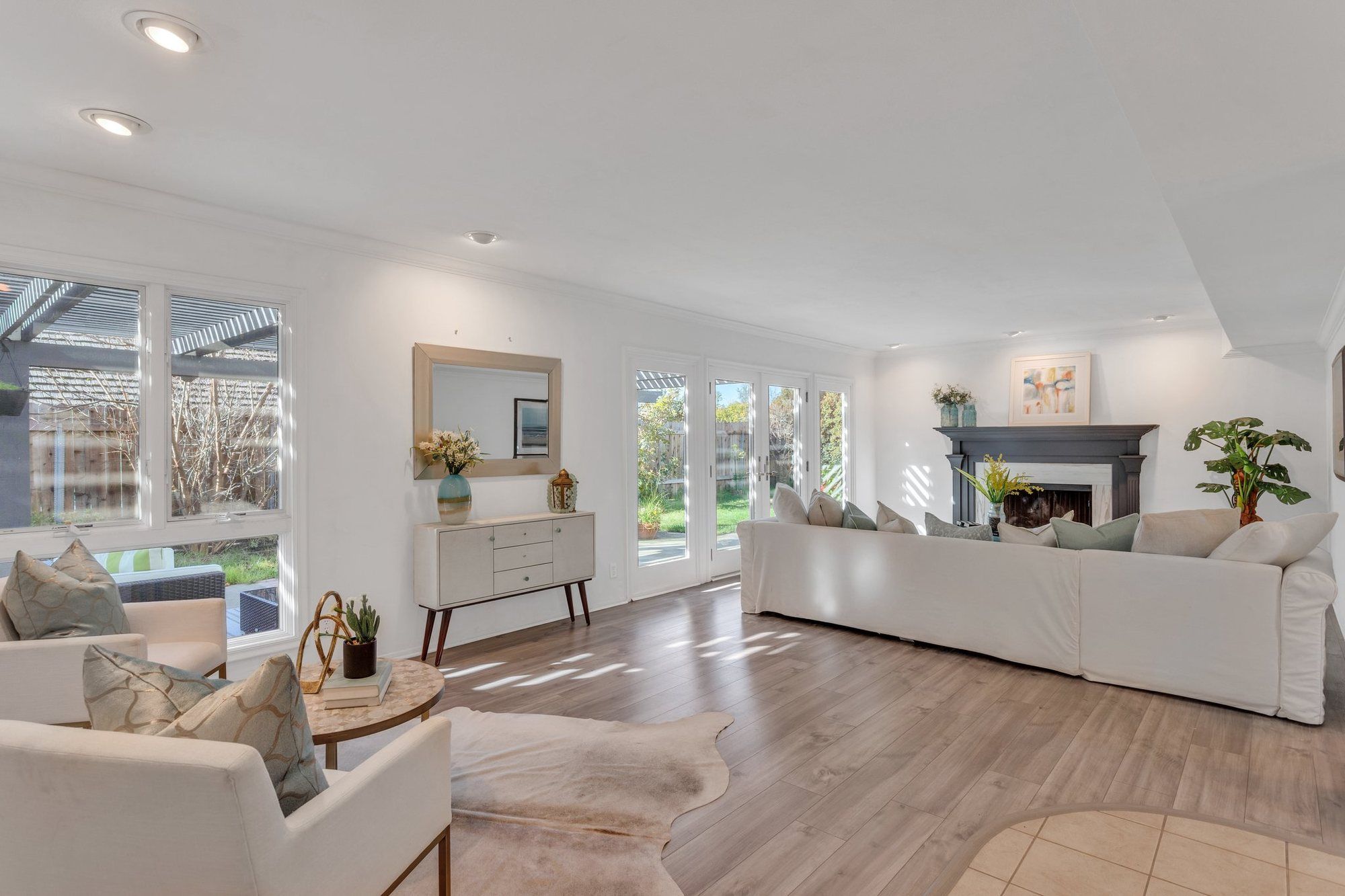 Living room with a white sofa, a dark fireplace and French doors to the yard, Tustin