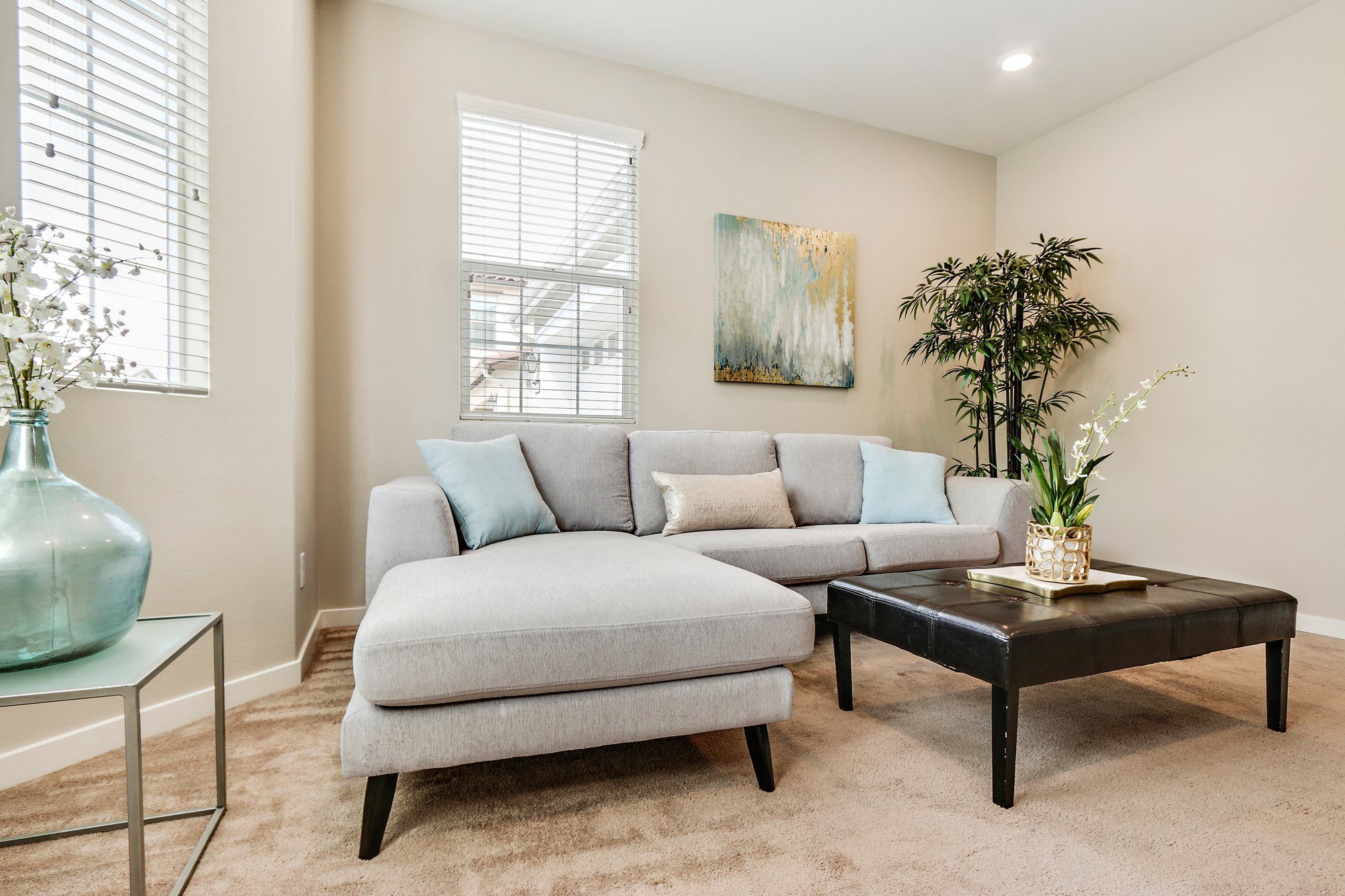 Gray sectional with pale blue pillows beside a tall bamboo plant, Irvine