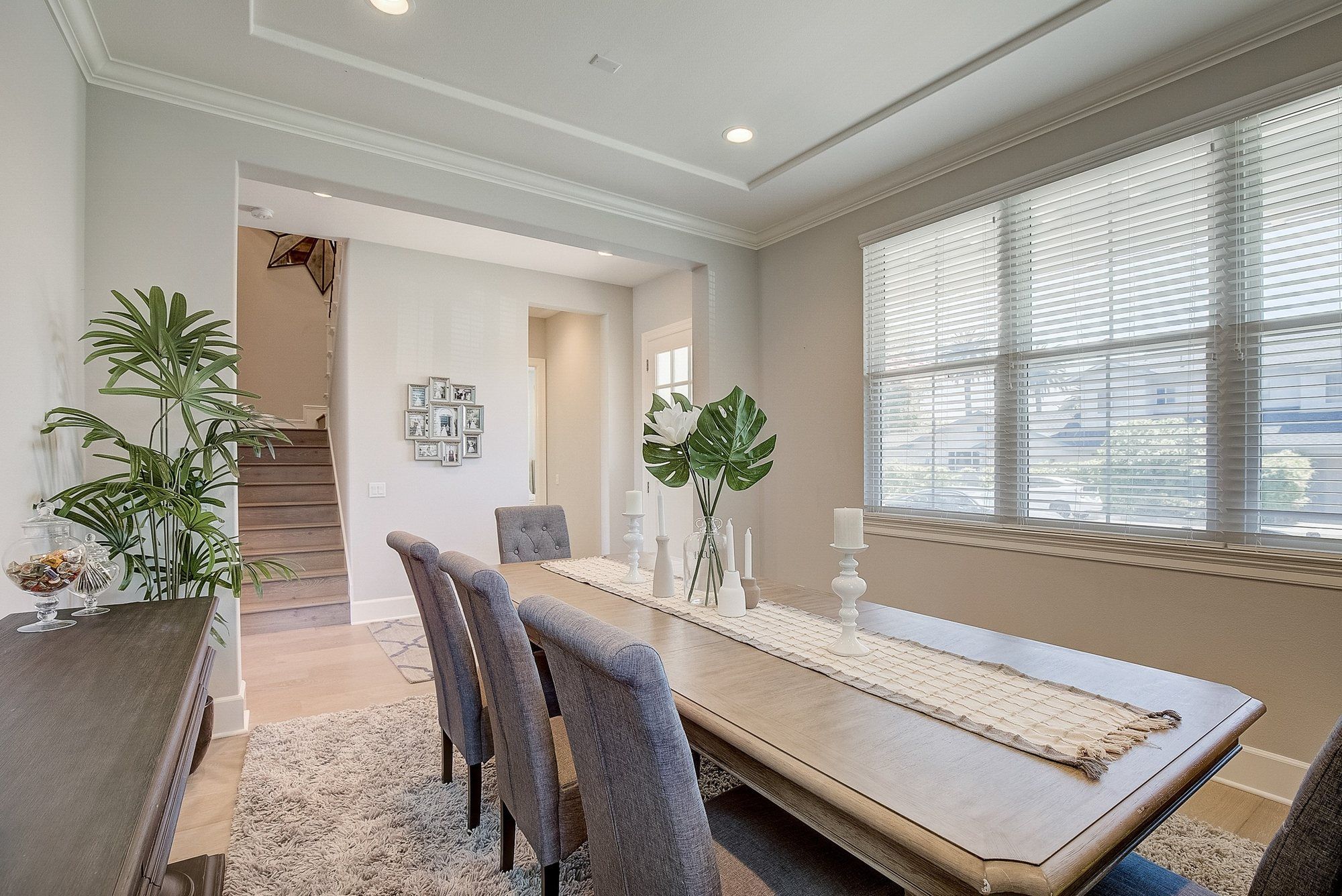 Dining table beside tall windows, with palms in the corners, Costa Mesa